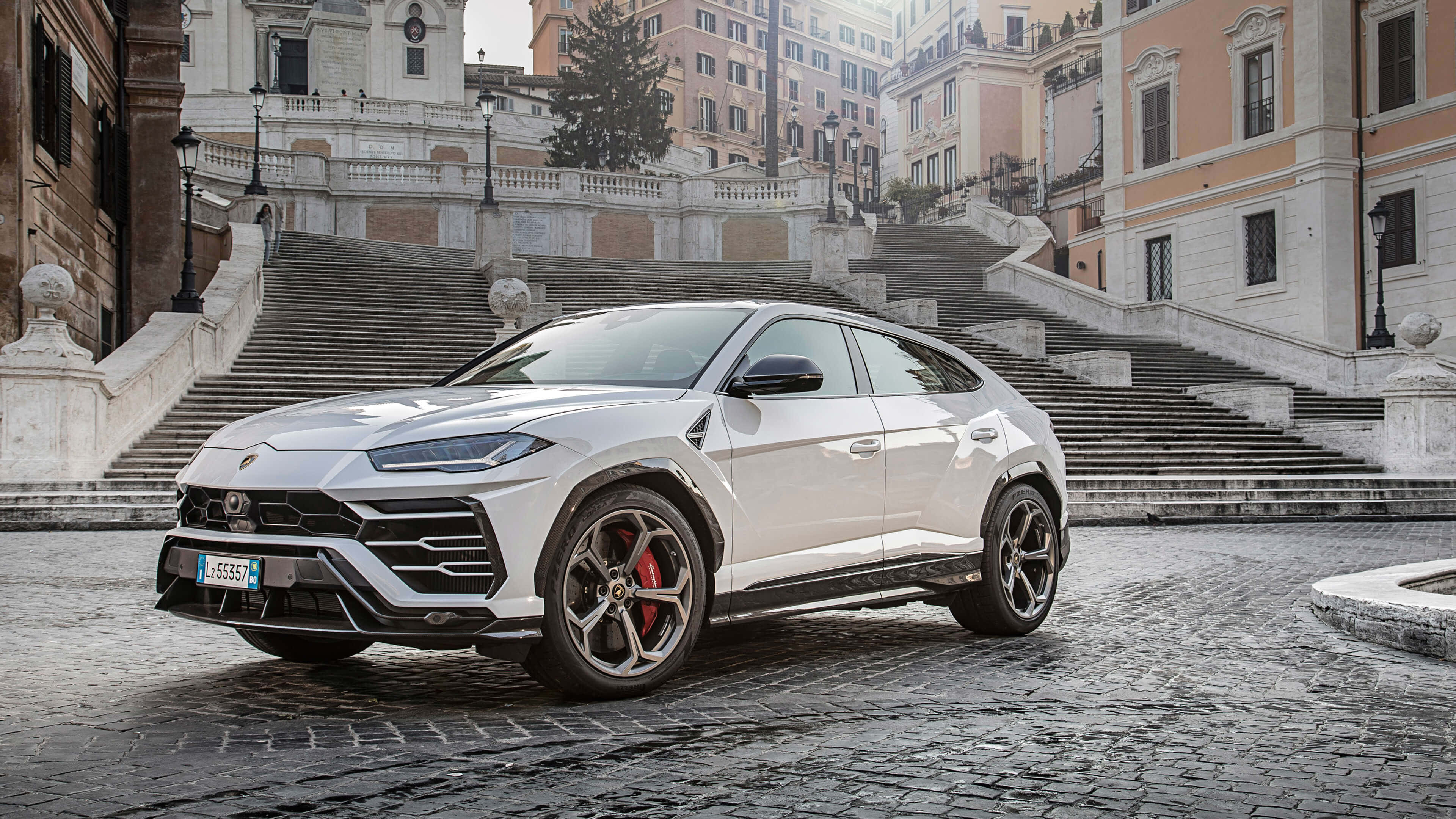 Lamborghini Urus 桌布 壁紙 — 一輛時尚的白色林寶堅尼Urus SUV停泊在歷史悠久的歐洲建築前的鵝卵石台階上。