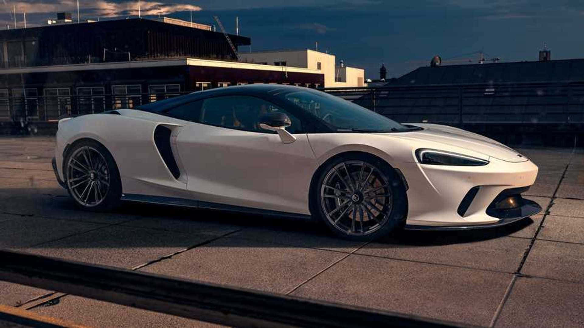 Mclaren Gt 桌布 壁紙 — 一架時尚的白色跑車在黃昏時停泊在天台上，背景是城市建築。