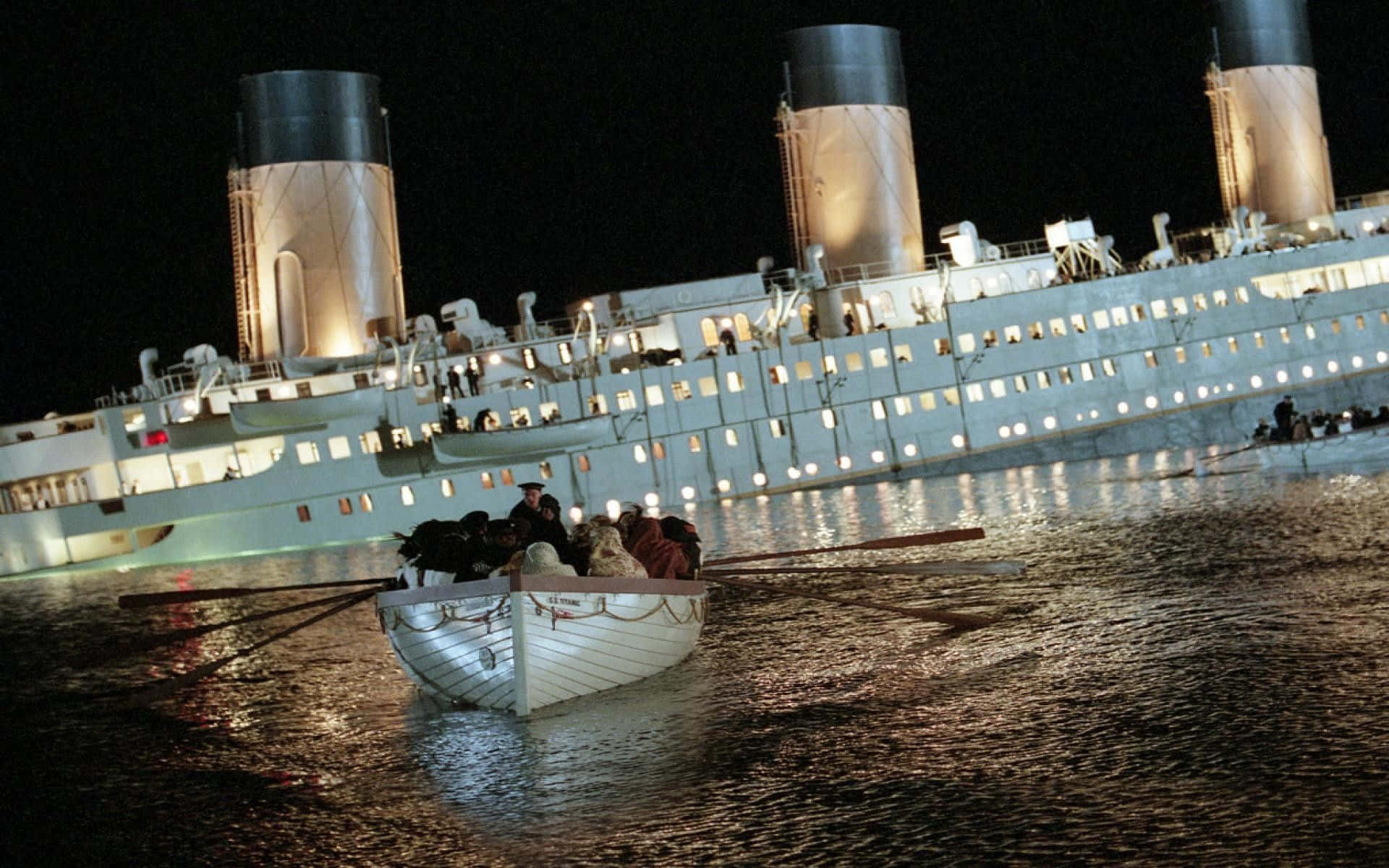Titanic Wreck 桌布 壁紙 — 一艘小救生艇在夜間載著乘客遠離沉沒的鐵達尼號，其燈光在黑暗的水面上閃爍。