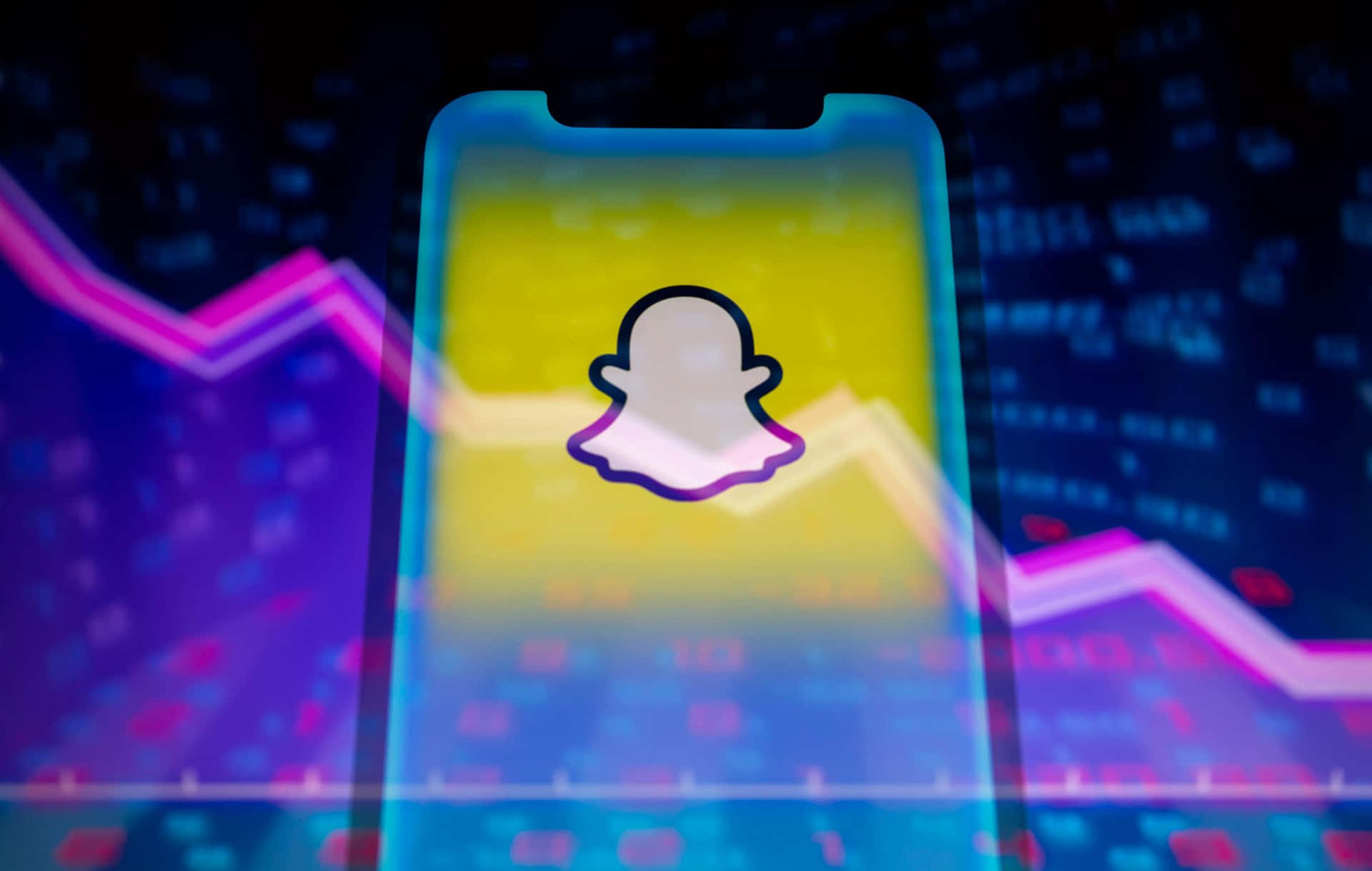  壁紙 — 一部顯示Snapchat標誌的智能手機在充滿活力的數位股票圖表（帶有螢光粉紅和藍色線條）前發光。