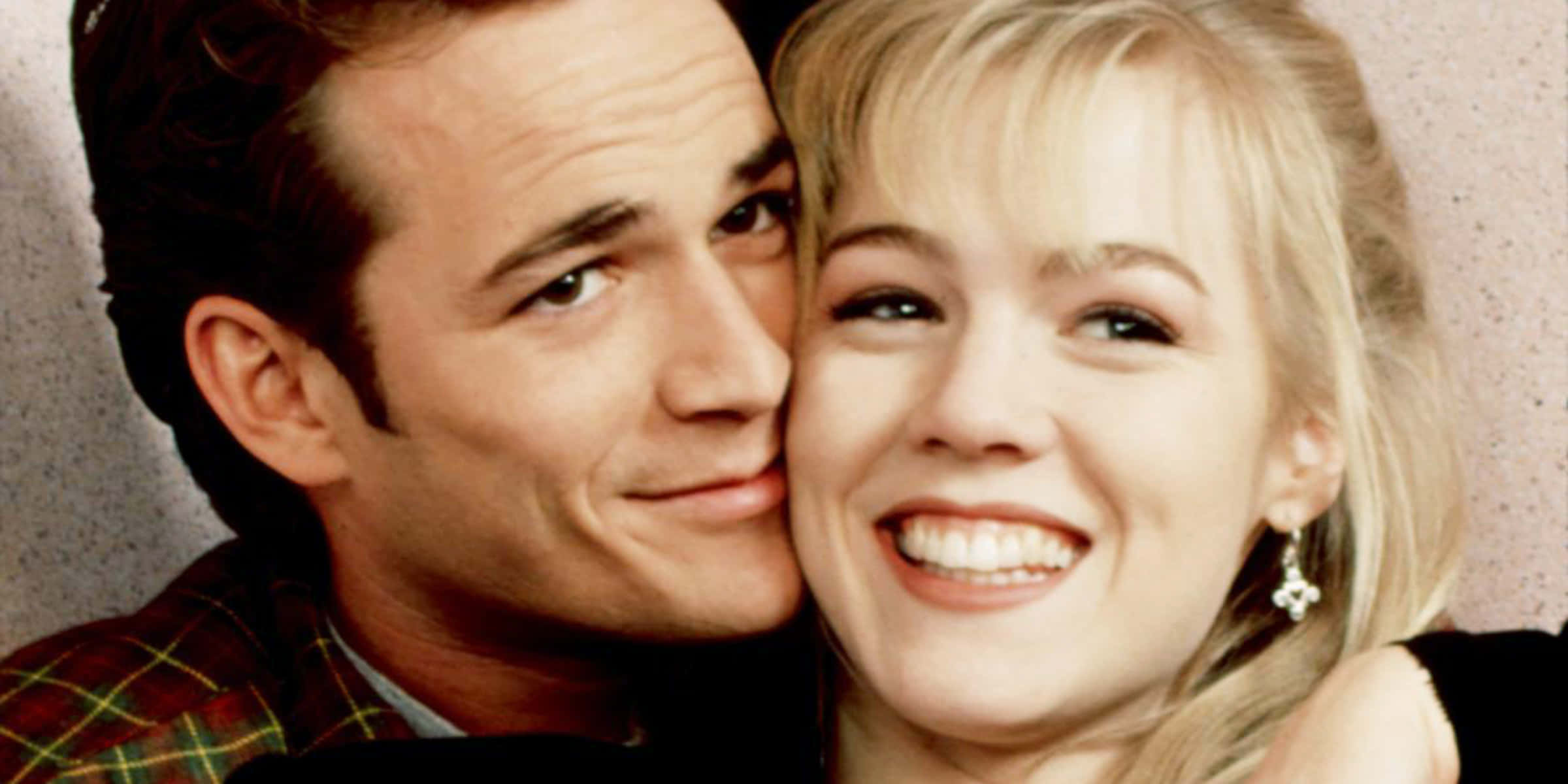 Jennie Garth 桌布 壁紙 — 一個微笑的男人和女人在紋理牆壁上溫暖地擁抱，在特寫肖像中散發出愛意和喜悅。