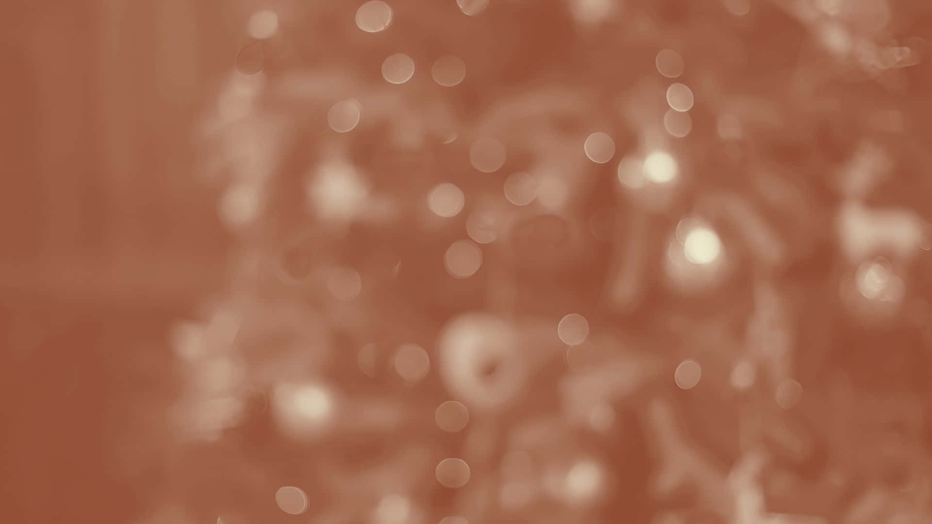  壁紙 — 柔和散景效果，帶有發光的圓形光點，襯托溫暖的懷舊棕色背景。