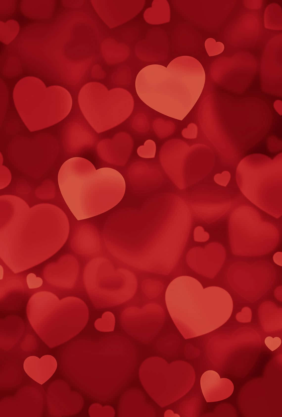 Red Heart 桌布 壁紙 — 一個柔和焦點的場地，充滿不同大小的發光紅色心形，營造出夢幻浪漫的氛圍。