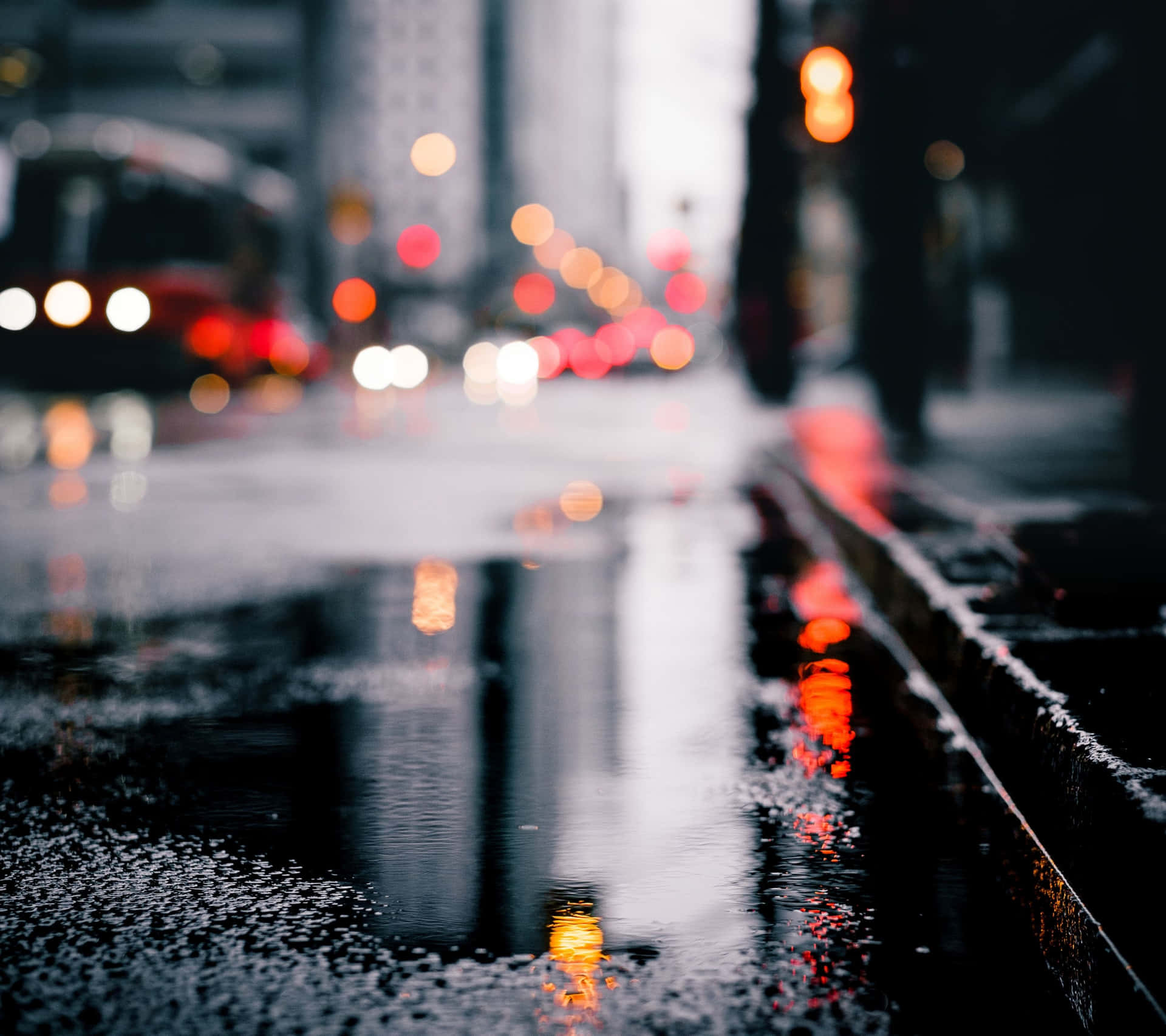 雨夜的街道，水坑中閃爍的車燈倒影。