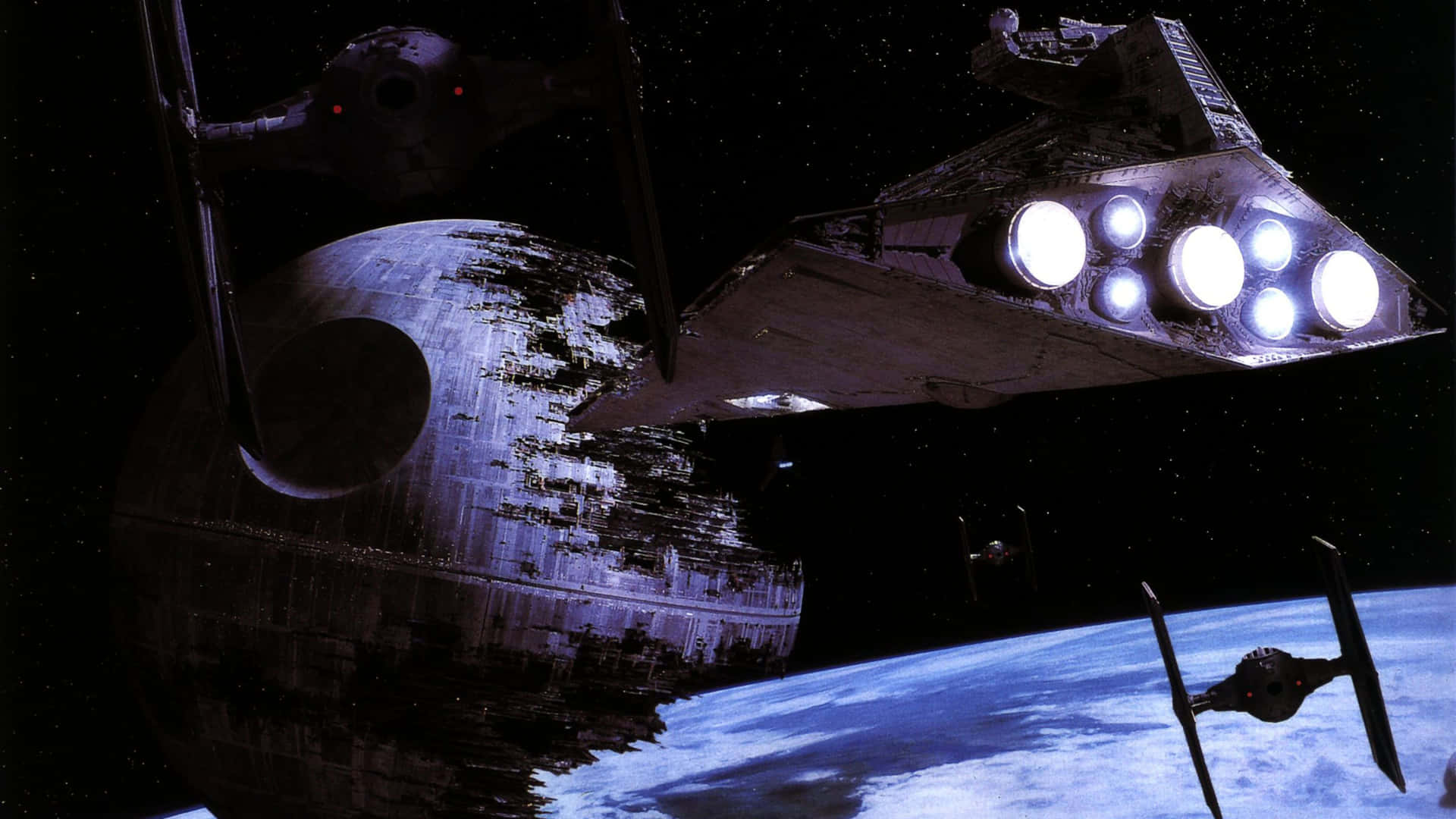  壁紙 — 一艘星際驅逐艦和TIE戰鬥機在深空中懸浮於藍色行星上方的死星附近。