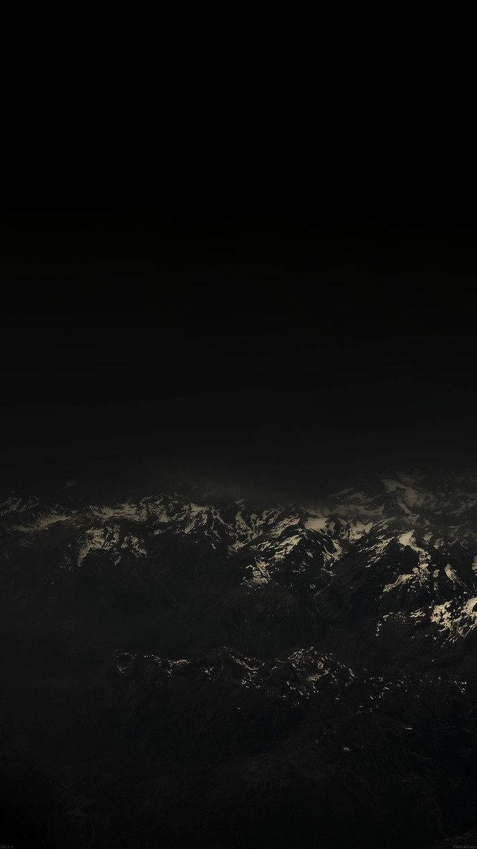 白雪覆蓋的山峰在黑暗的夜空中呈現剪影。