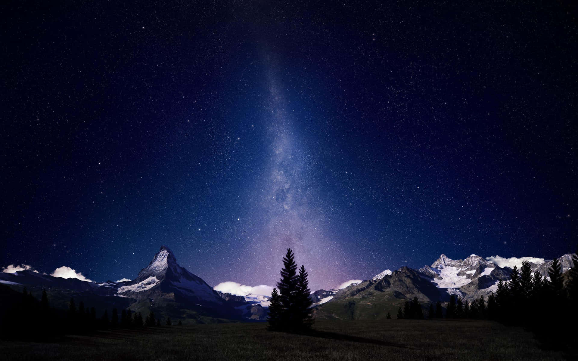  壁紙 — 星空之夜，銀河拱跨雪覆山巒與孤松剪影。