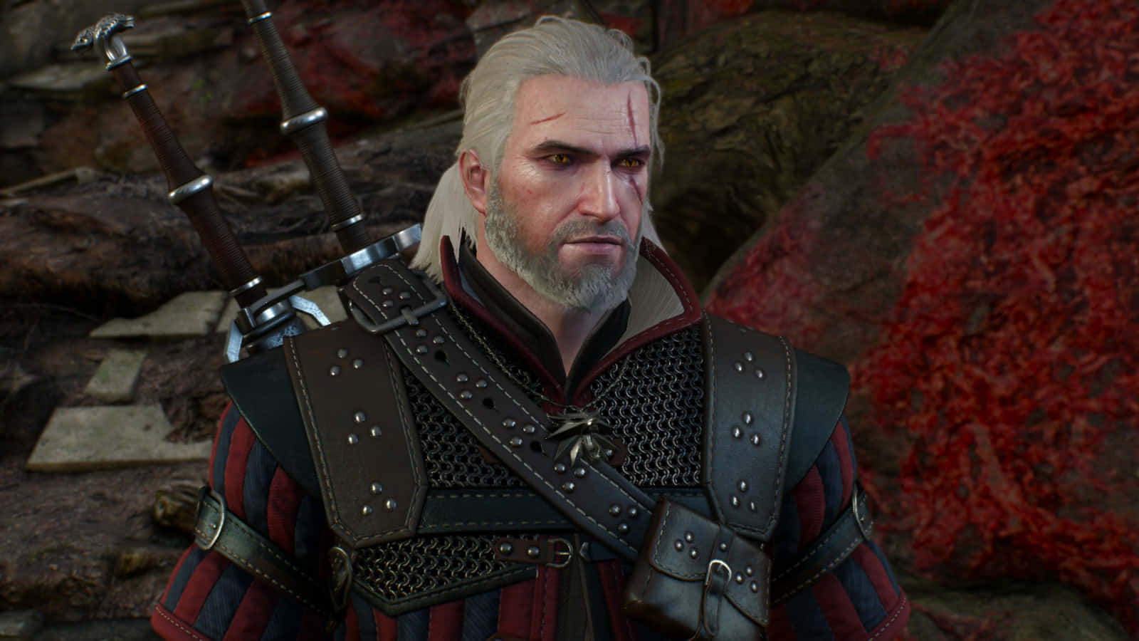 Geralt Of Rivia 桌布 壁紙 — 一位嚴肅的白髮戰士身穿皮甲，背負雙劍，站在帶有紅色紋理的岩石構造前。