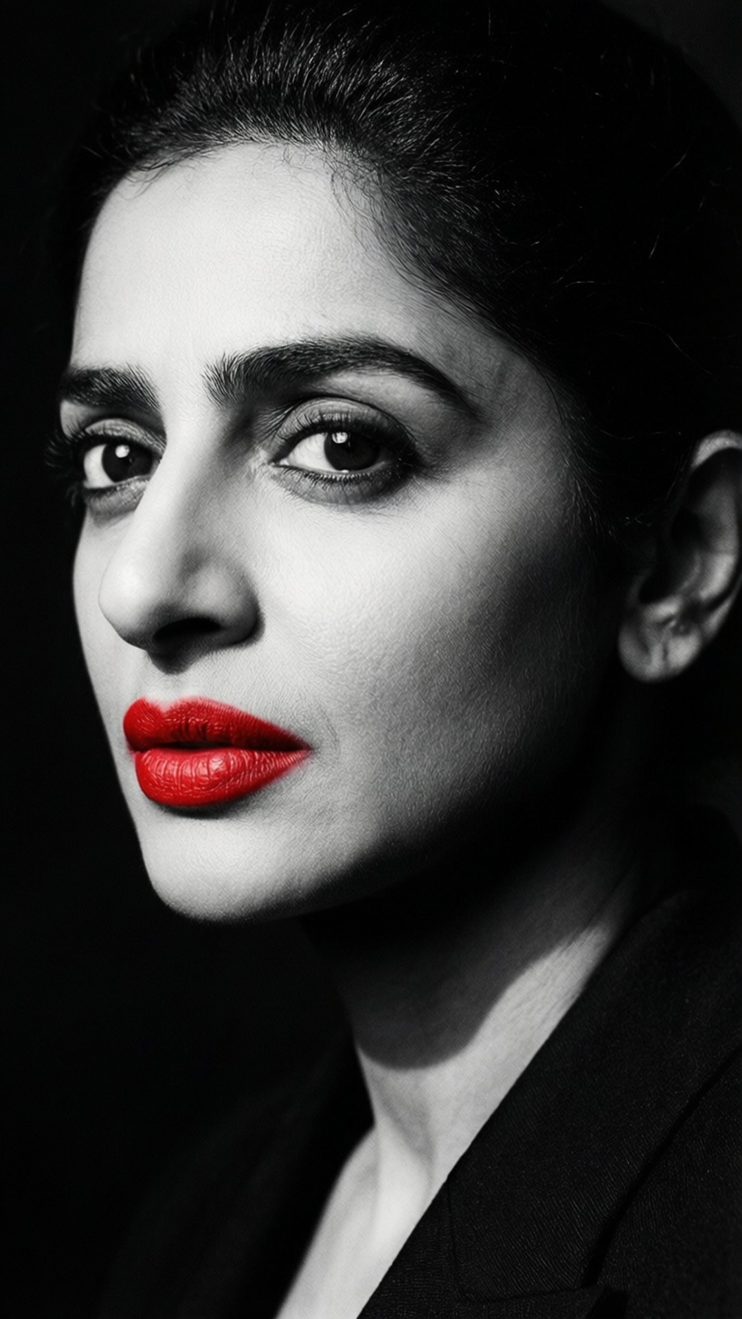 Rani Mukerji 桌布 壁紙 — 一個引人注目的黑白肖像，描繪一位擁有鮮豔紅唇和強烈眼神的女性，背景為深色。