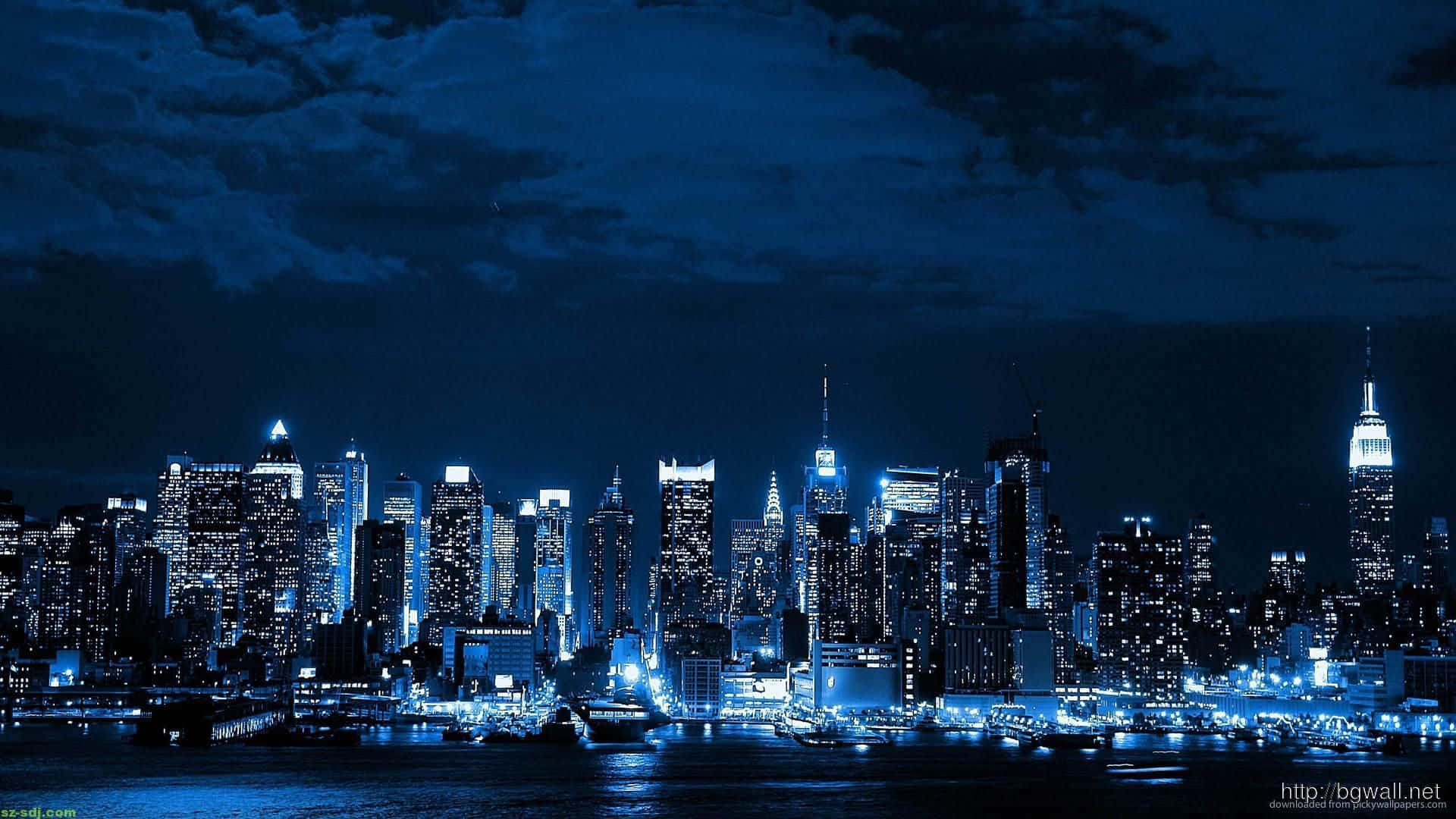 都市閃耀天堂 壁紙 — 紐約令人驚嘆的夜景，摩天大樓在深藍色天空下在水面上閃閃發光。