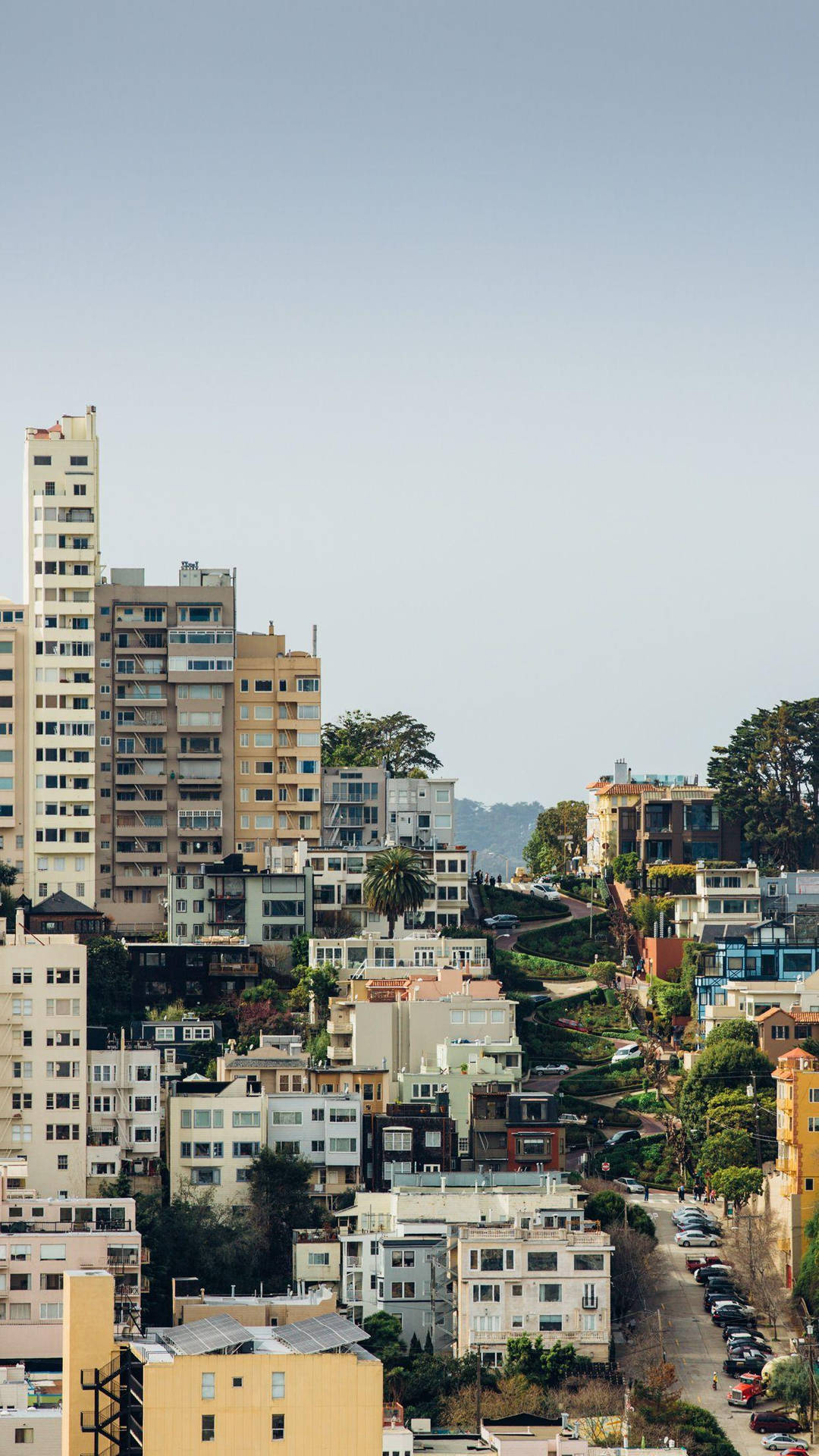 山坡城市，在晴朗的天空下擁有色彩繽紛的房屋和現代建築。
