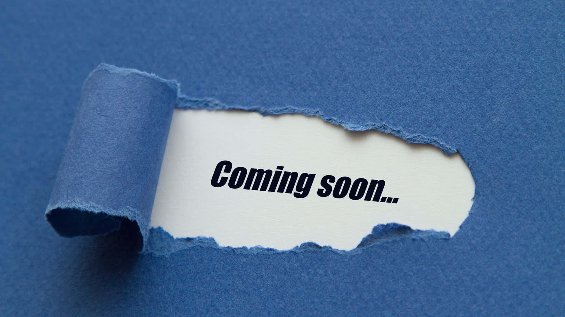 撕破的藍色紙張露出「Coming soon...」文字。