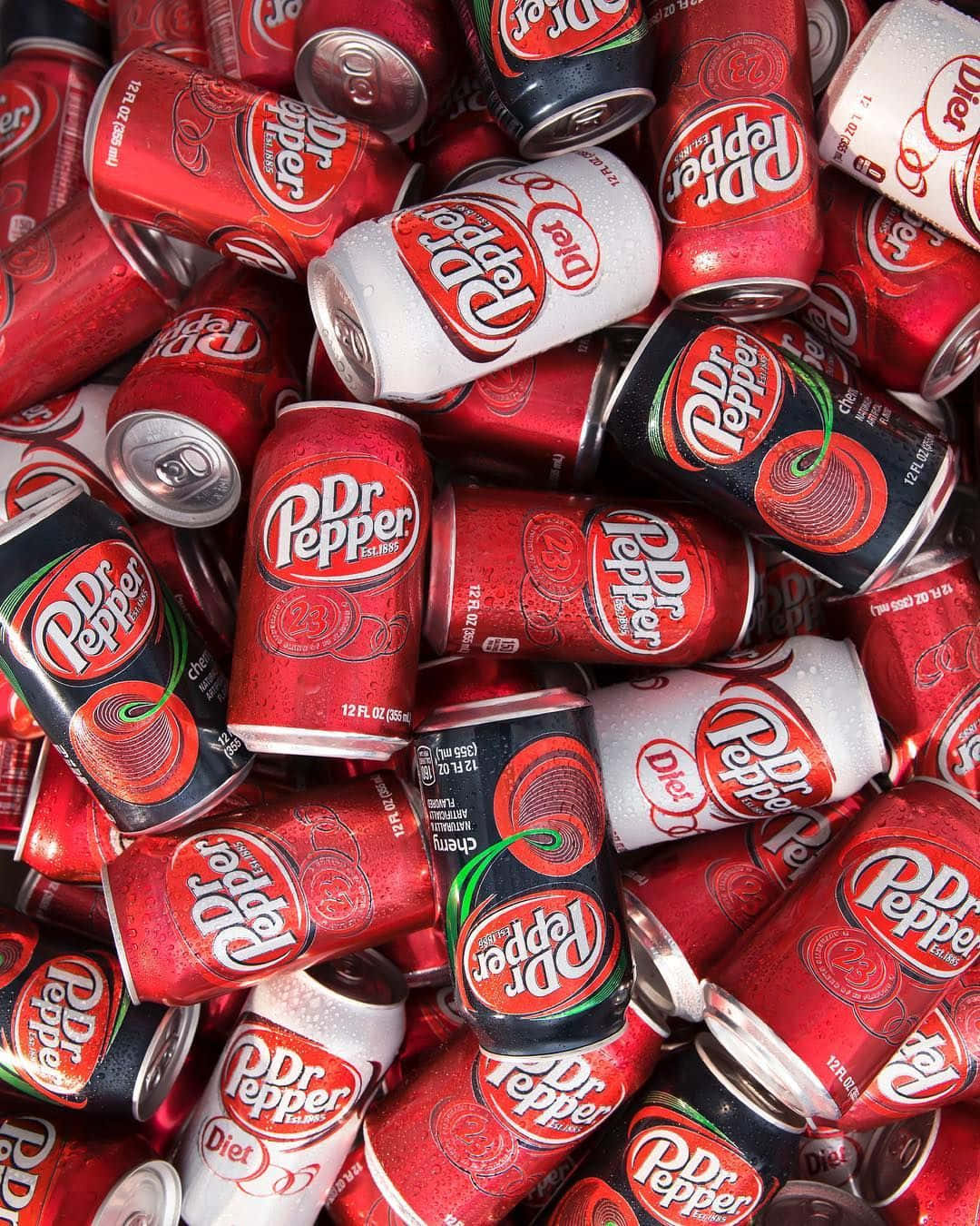  壁紙 — 一個充滿活力的特寫鏡頭，展示各種 Dr Pepper 汽水罐堆疊在一起，表面凝結的水珠閃閃發光。