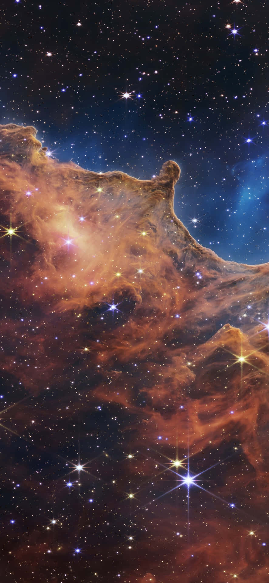  壁紙 — 一個充滿活力的宇宙星雲，有發光的橙色和藍色雲層，以及閃爍的星星，背景是深邃的黑色天空。