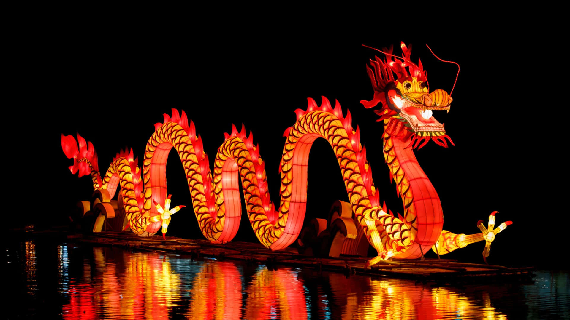  壁紙 — 一盞鮮紅和金色發光的龍燈籠在夜晚平靜地漂浮在黑暗的水面上，其倒影在下方閃爍。