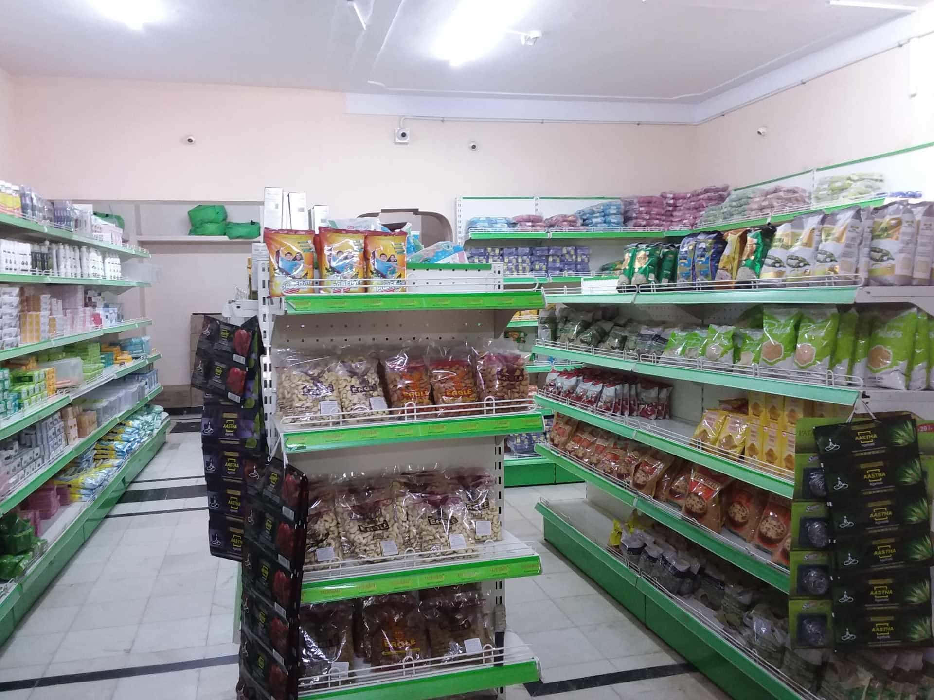 明亮燈光下，雜貨店通道有綠色貨架和包裝零食。
