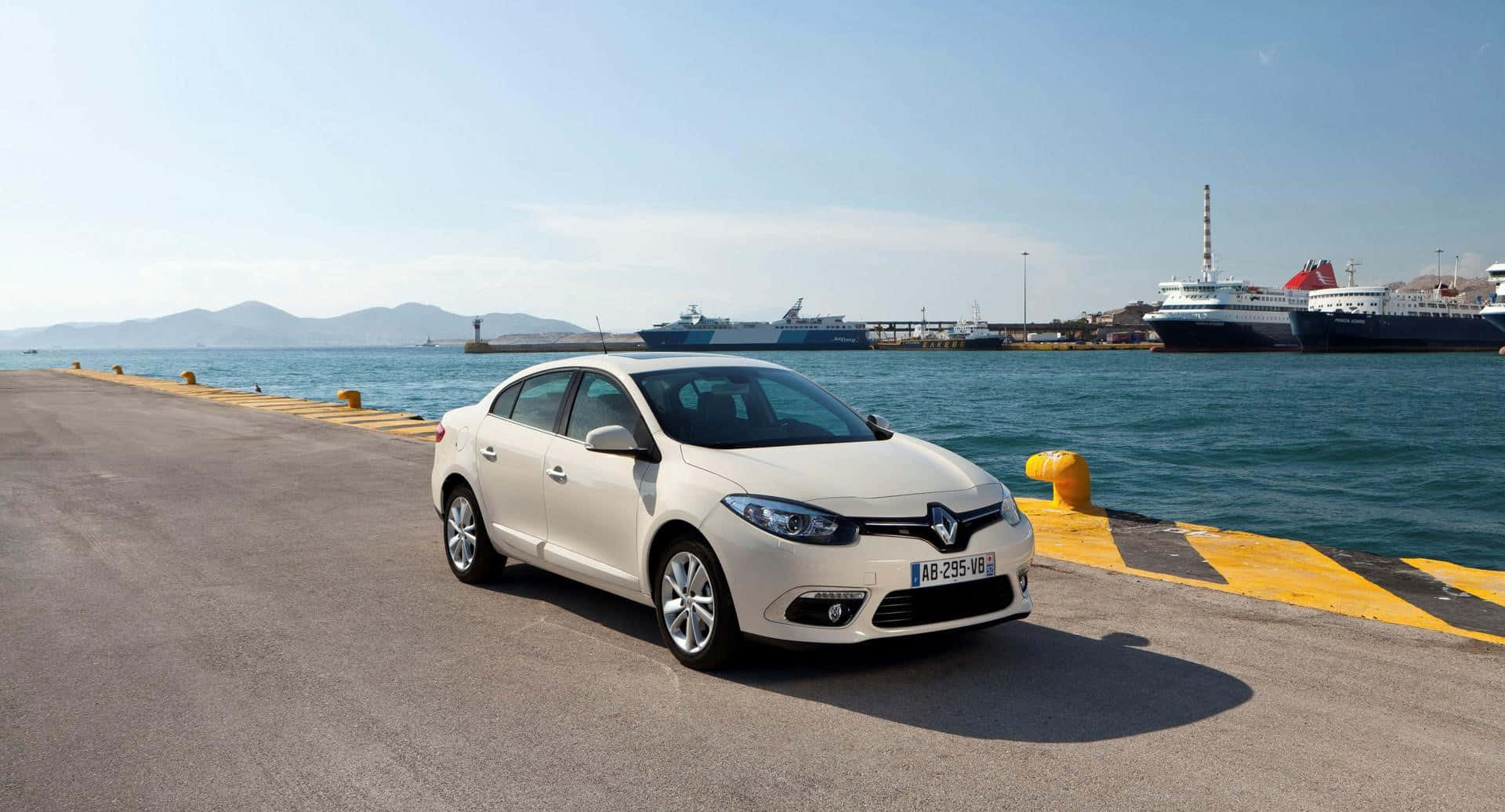 Renault Fluence 桌布 壁紙 — 一輛白色雷諾房車停泊在陽光明媚的港口碼頭，背景有郵輪和山脈。