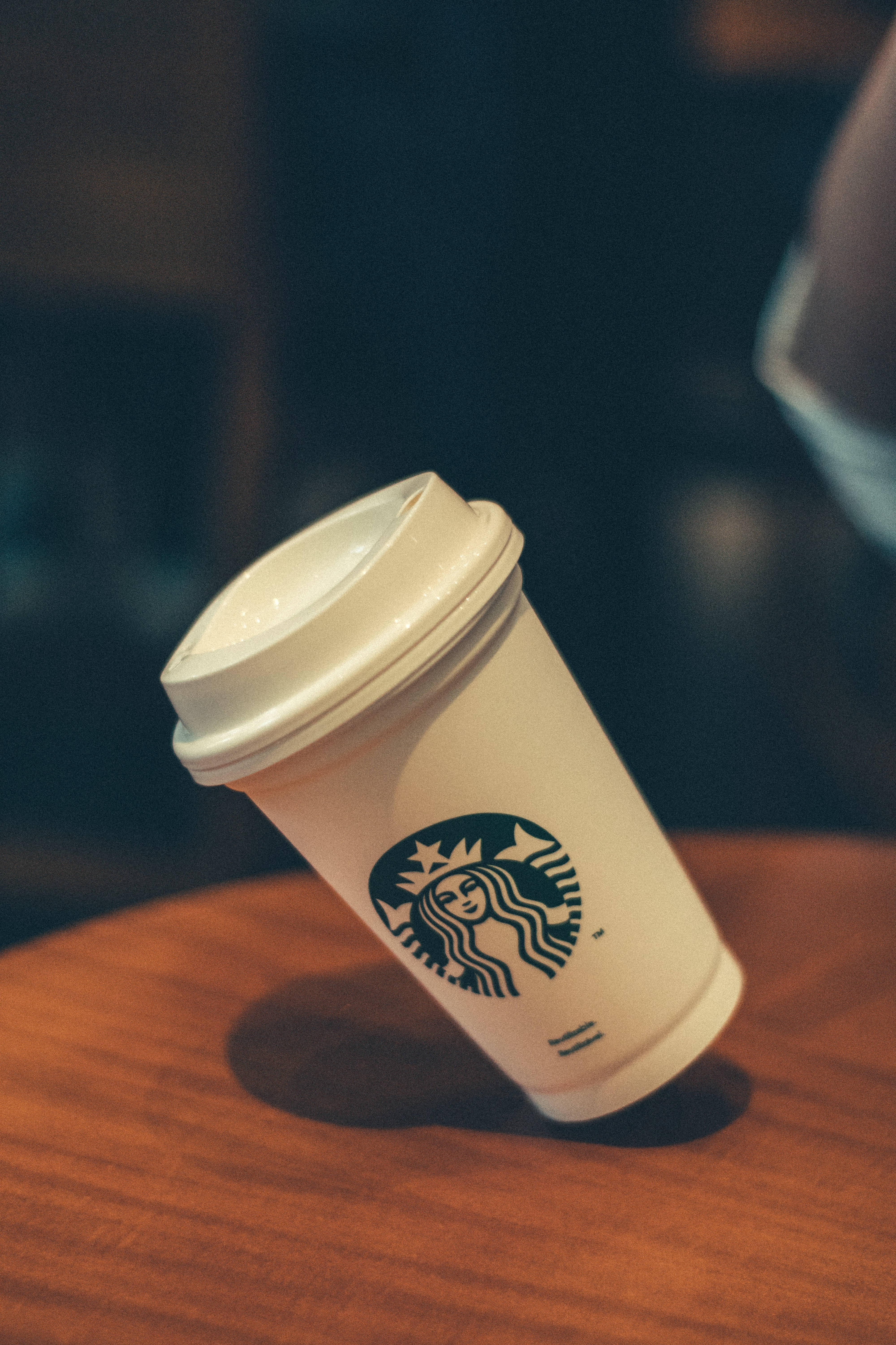 在舒適的咖啡店環境中，木桌上的一個Starbucks咖啡杯。