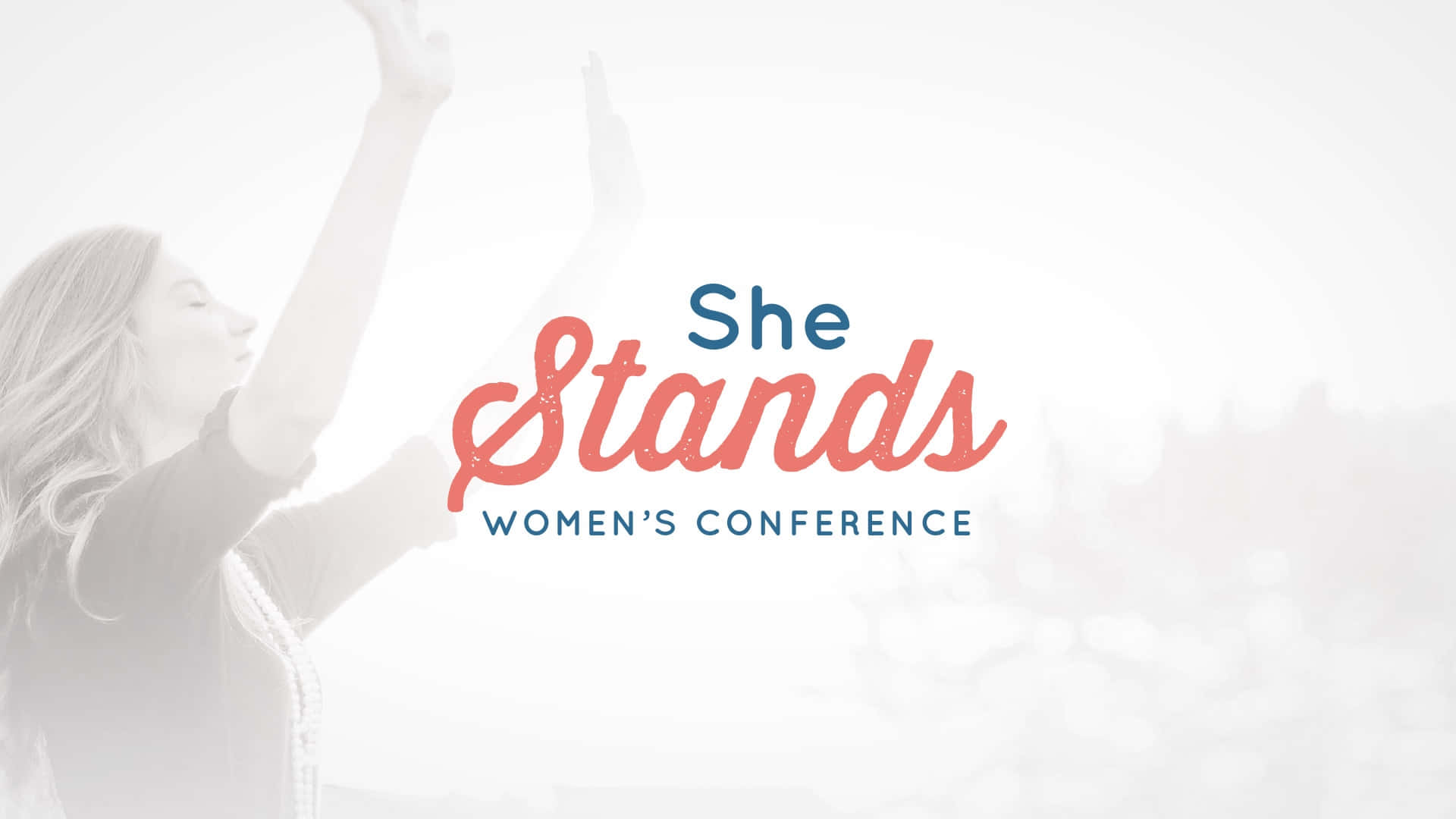  壁紙 — 一位女性在明亮的白色背景上，高舉雙臂，身後是粗體的「She Stands Women's Conference」文字。