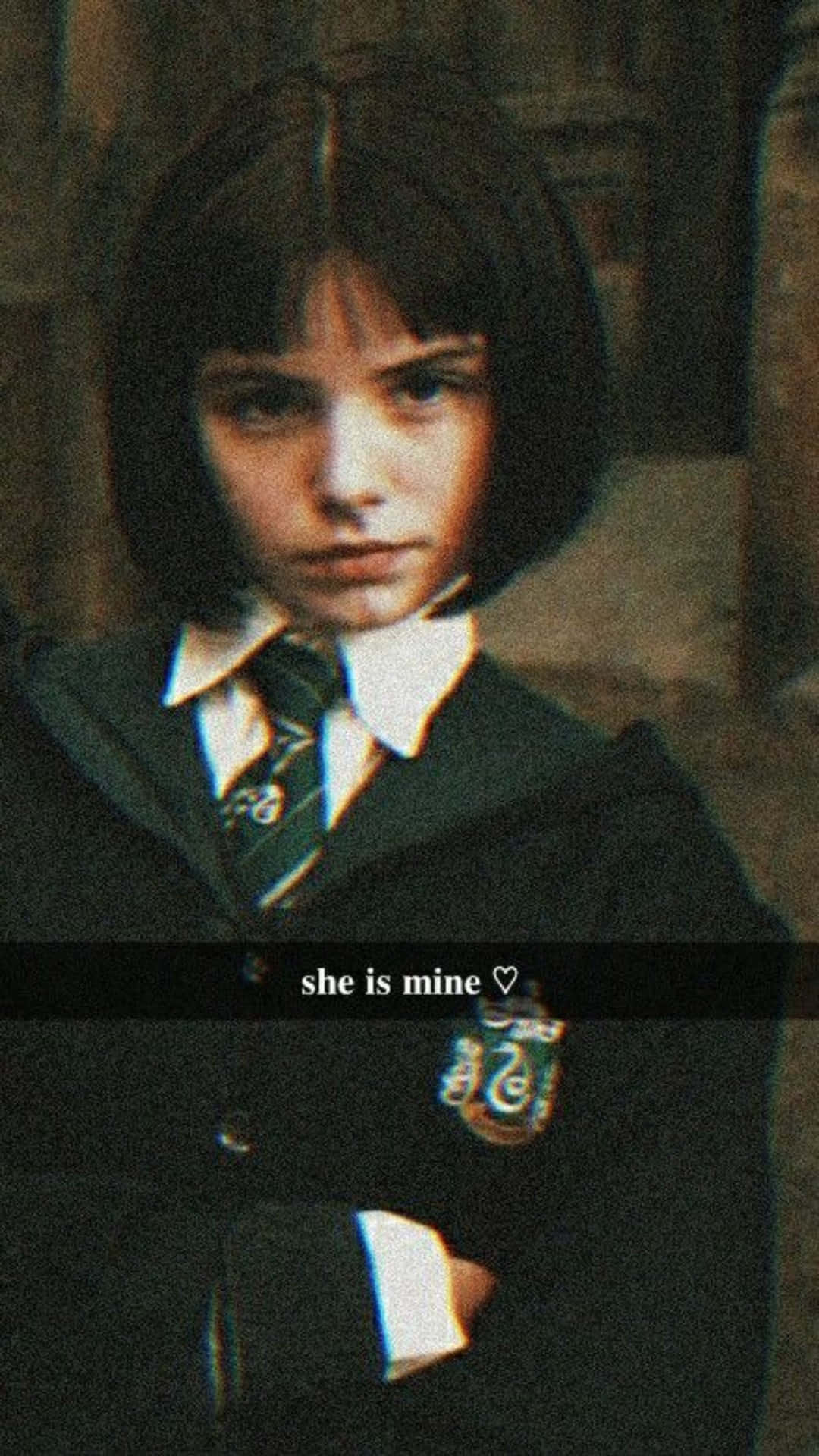  壁紙 — 一個穿著深色校服、繫著綠色領帶和校徽的年輕女孩，在模糊的石頭背景下，專注地凝視著鏡頭。