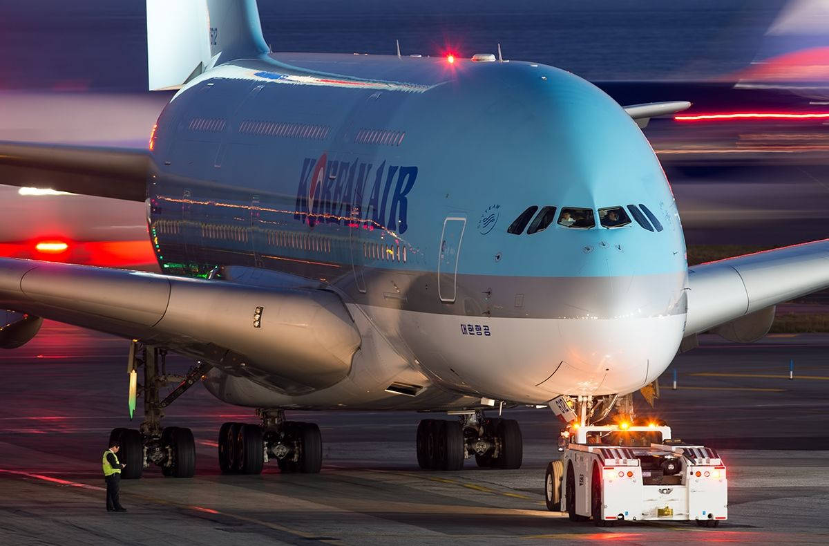 韓亞航空空中巴士 A380 壁紙 — 一架大韓航空空中巴士A380在黃昏時被拖行，模糊的跑道燈光在後方劃過。