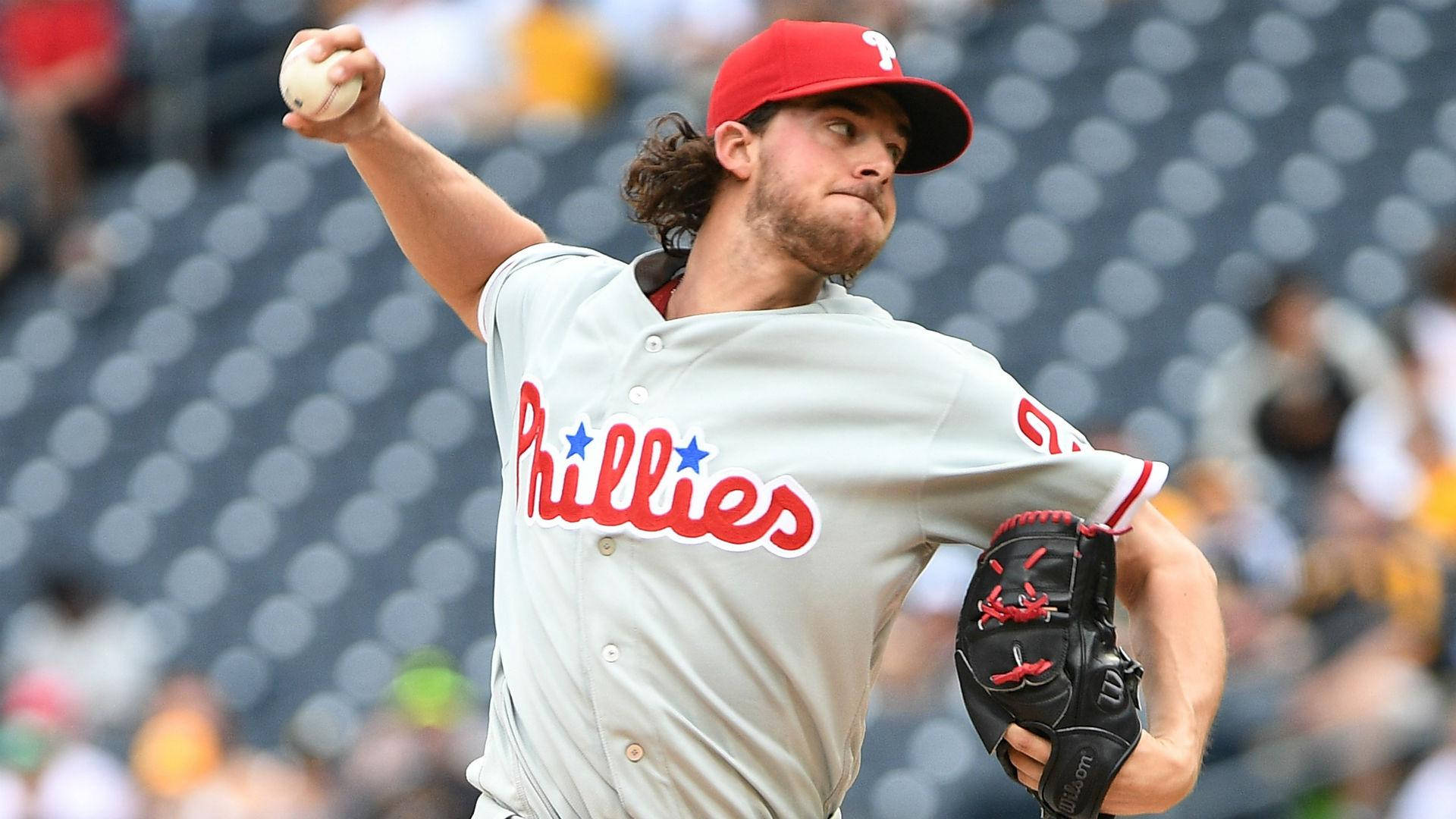 Aaron Nola 強力投球 壁紙 — 費城費城人隊的棒球投手在日間比賽中專注地投球。