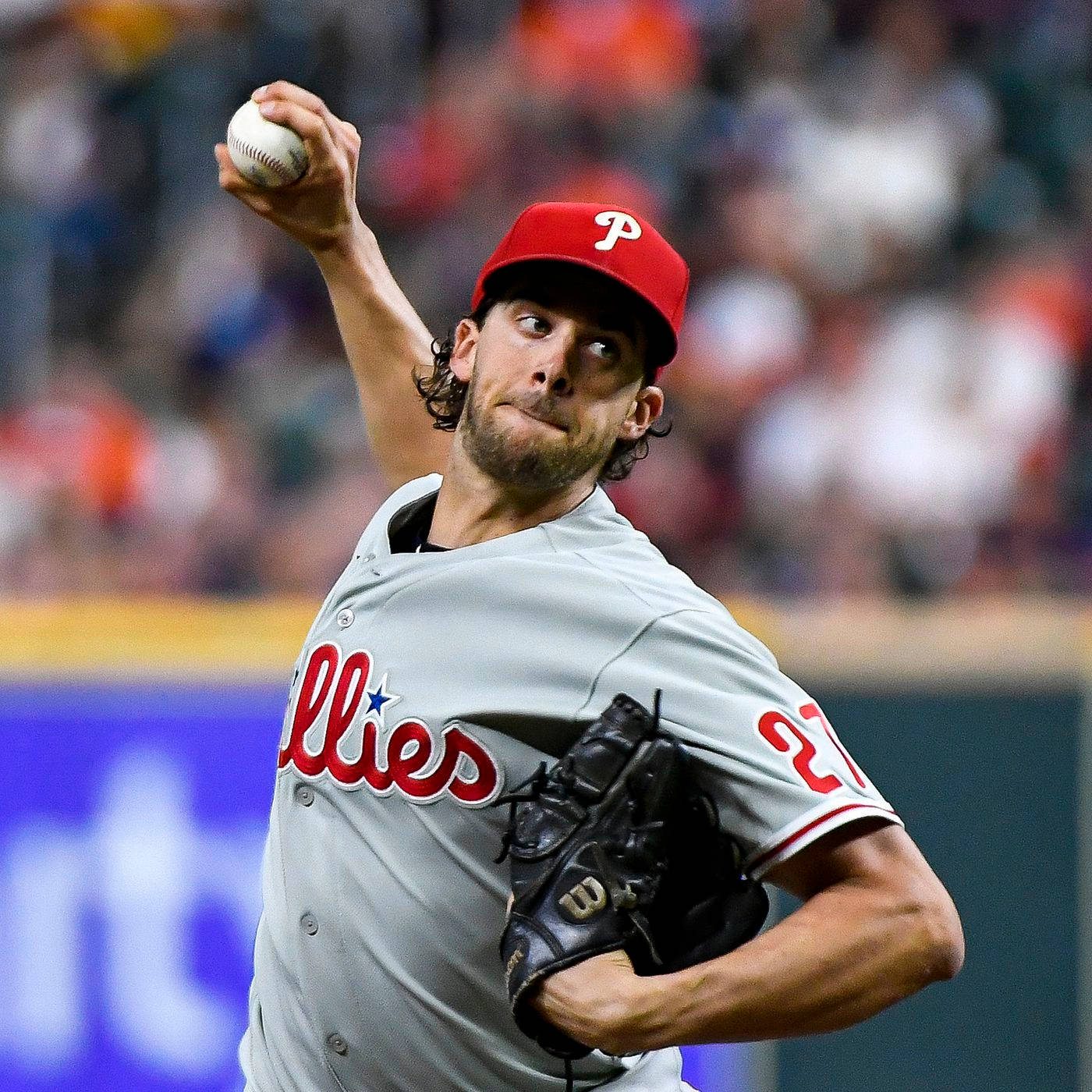 Aaron Nola 握球待投 壁紙 — 一名身穿費城人隊球衣的棒球投手在夜間比賽中，在球場燈光下專注投球。