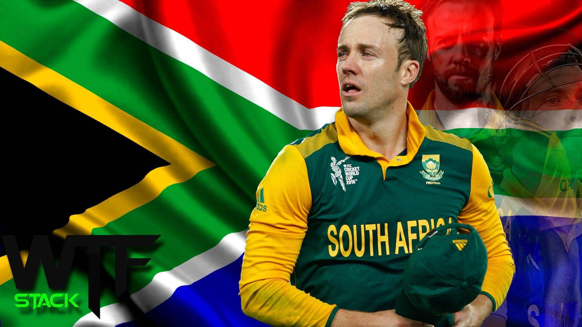 AB de Villiers 對抗南非國旗 壁紙 — 一名身穿綠色和黃色球衣的南非板球運動員，在飄揚的南非國旗背景下手持帽子。