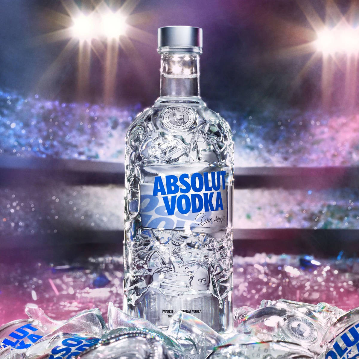Absolut Vodka酒瓶被破碎的玻璃包圍，在體育場燈光下。
