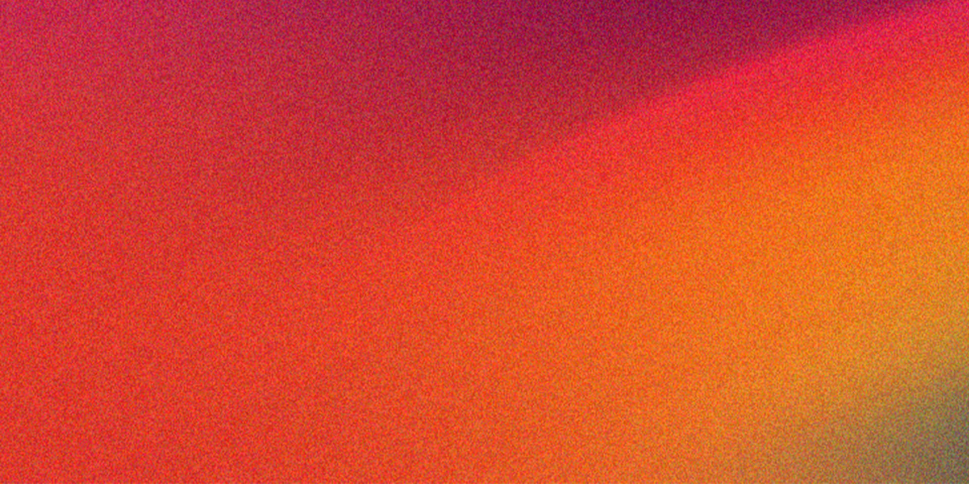 Abstract Warm Color Gradient Background Texture with Subtle Grain 壁紙 — 充滿活力的抽象漸變從深洋紅色到火橙色對角流動，帶有微妙的顆粒紋理。