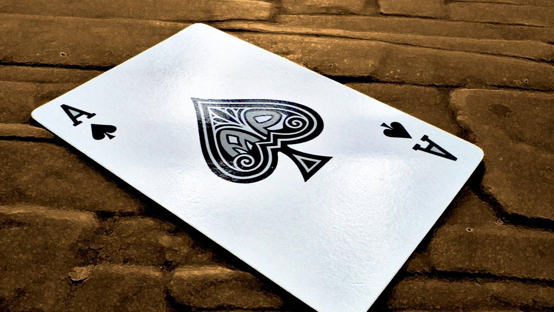 磚背景上嘅銀色葵扇Ace啤牌