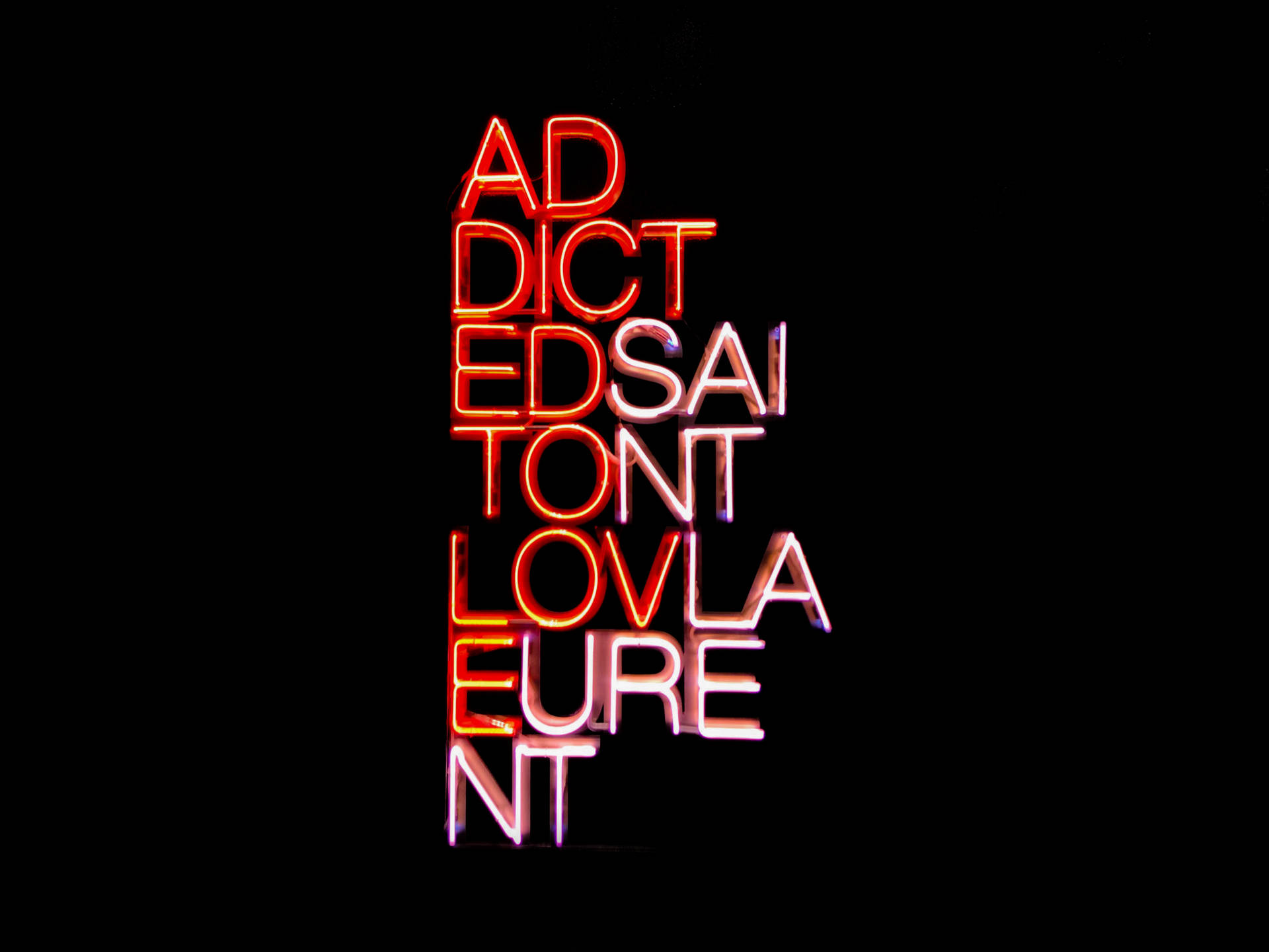 黑色背景上紅色和白色的霓虹燈牌寫著 addicted to love
