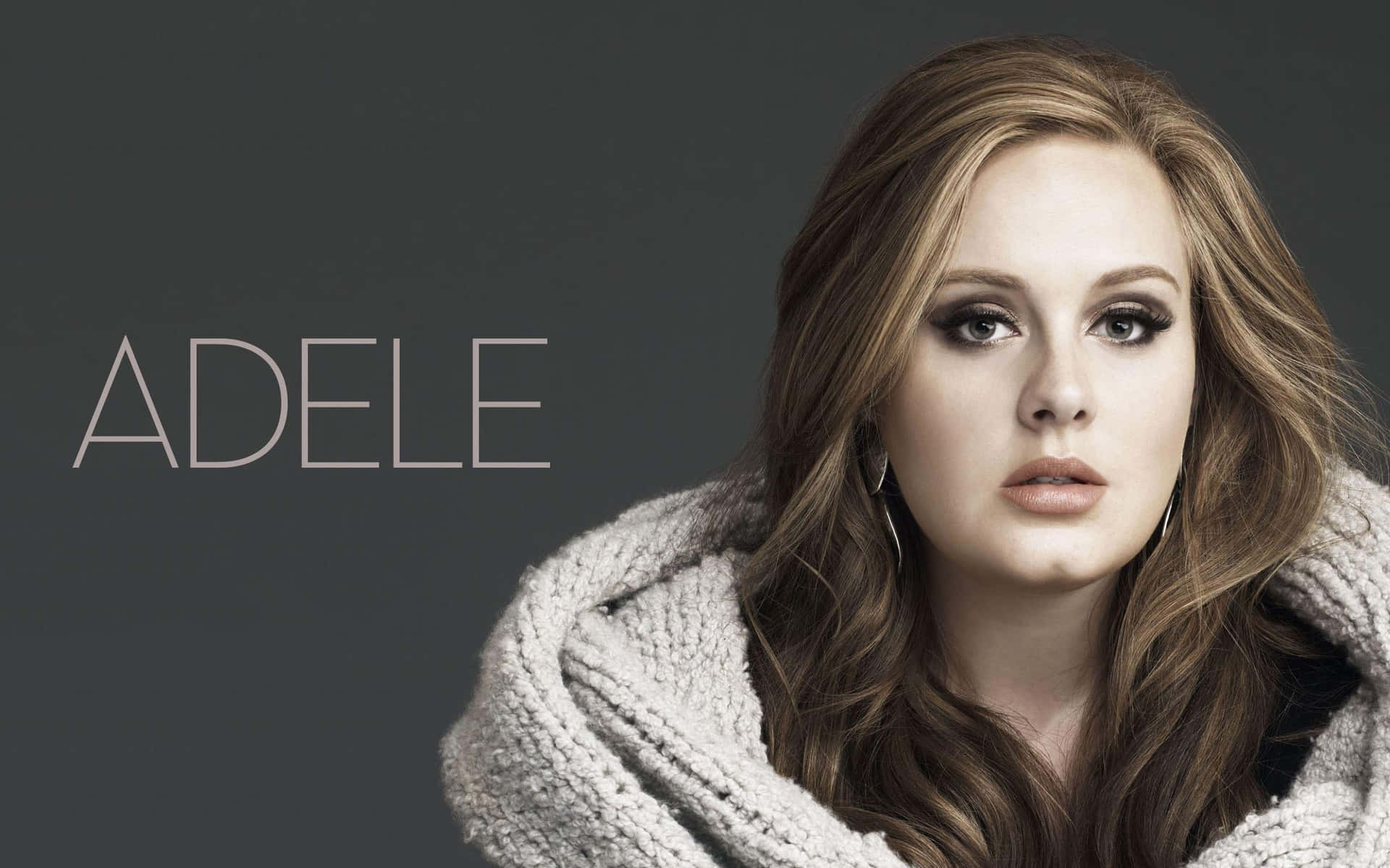 Adele 裹著白色質感毛毯，在攝影棚肖像中直視鏡頭。