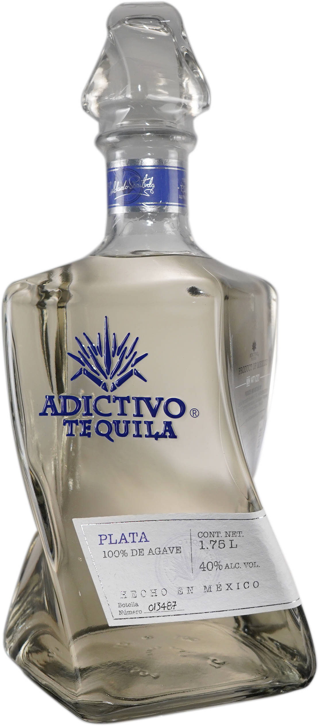 Adictivo Plata Tequila in a Clear Bottle 壁紙 — 一個透明玻璃瓶的Adictivo Tequila Plata，帶有藍色品牌和標籤細節，背景為白色。