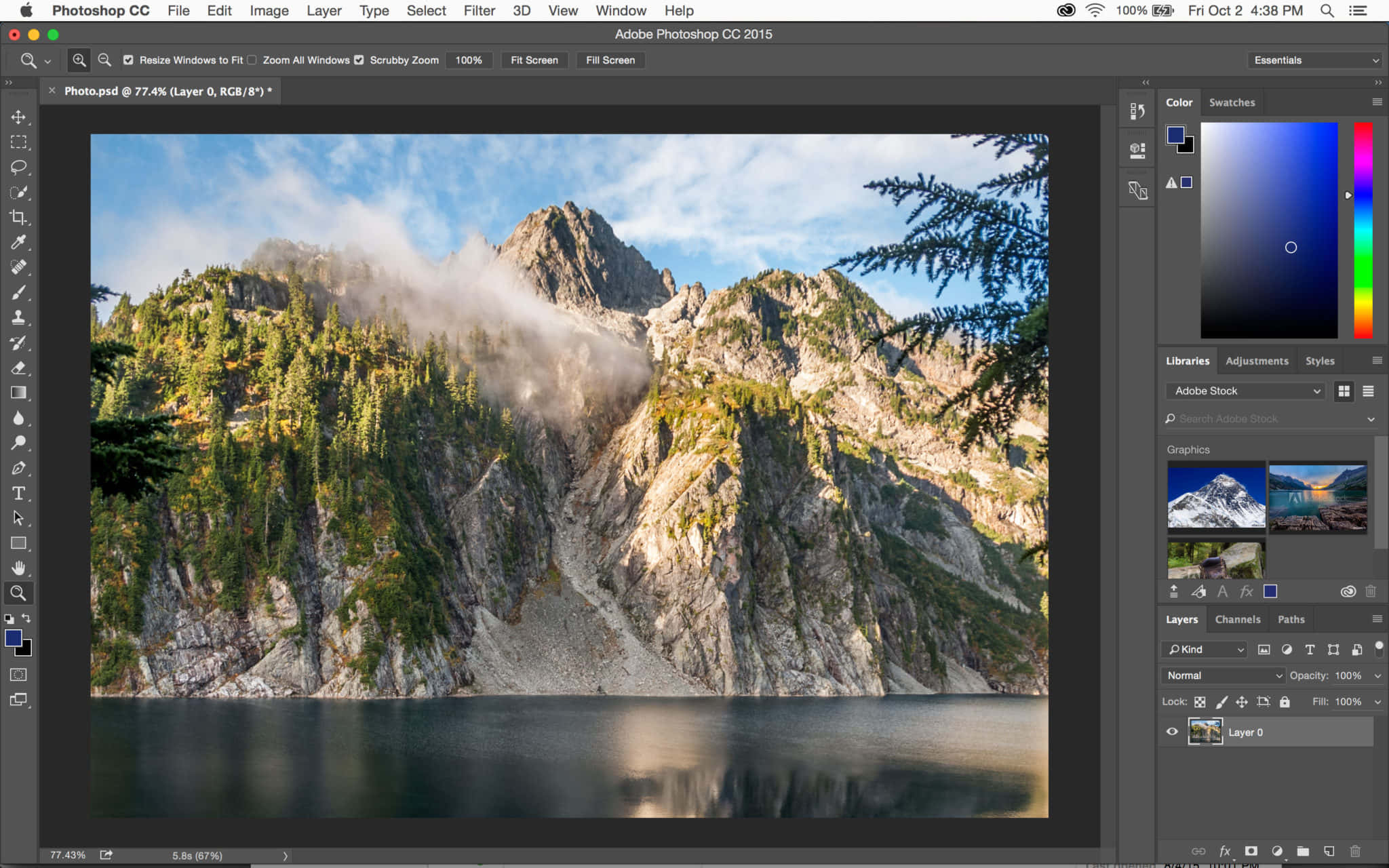 以Adobe Photoshop釋放你的創意！ 壁紙 — 一個霧氣繚繞的山峰，常綠樹木在明亮的藍天下倒映在平靜的湖面上。