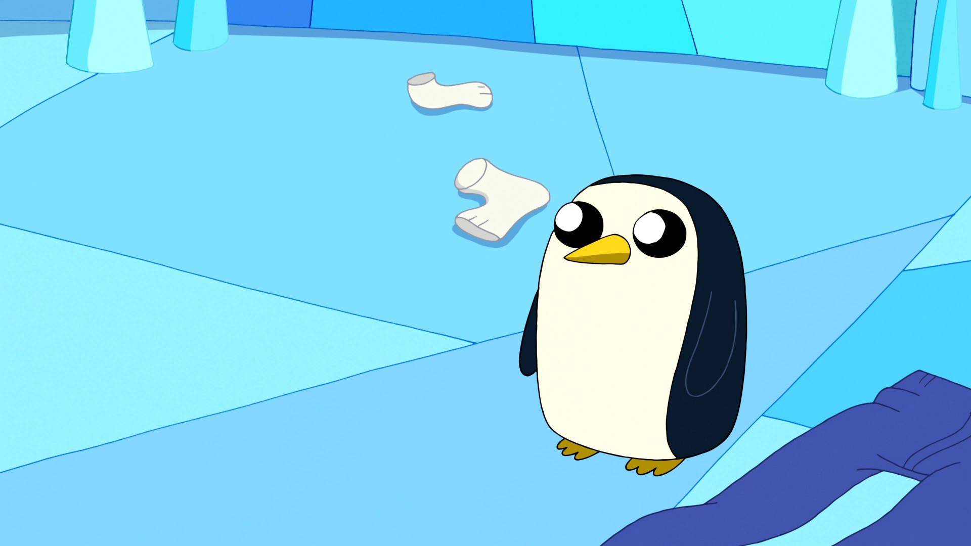 Adventure Time Gunter 在衣櫥內 壁紙 — 一隻卡通企鵝睜大眼睛，站在藍色冰室裡，旁邊有漂浮的白襪子和一堆藍色布料。