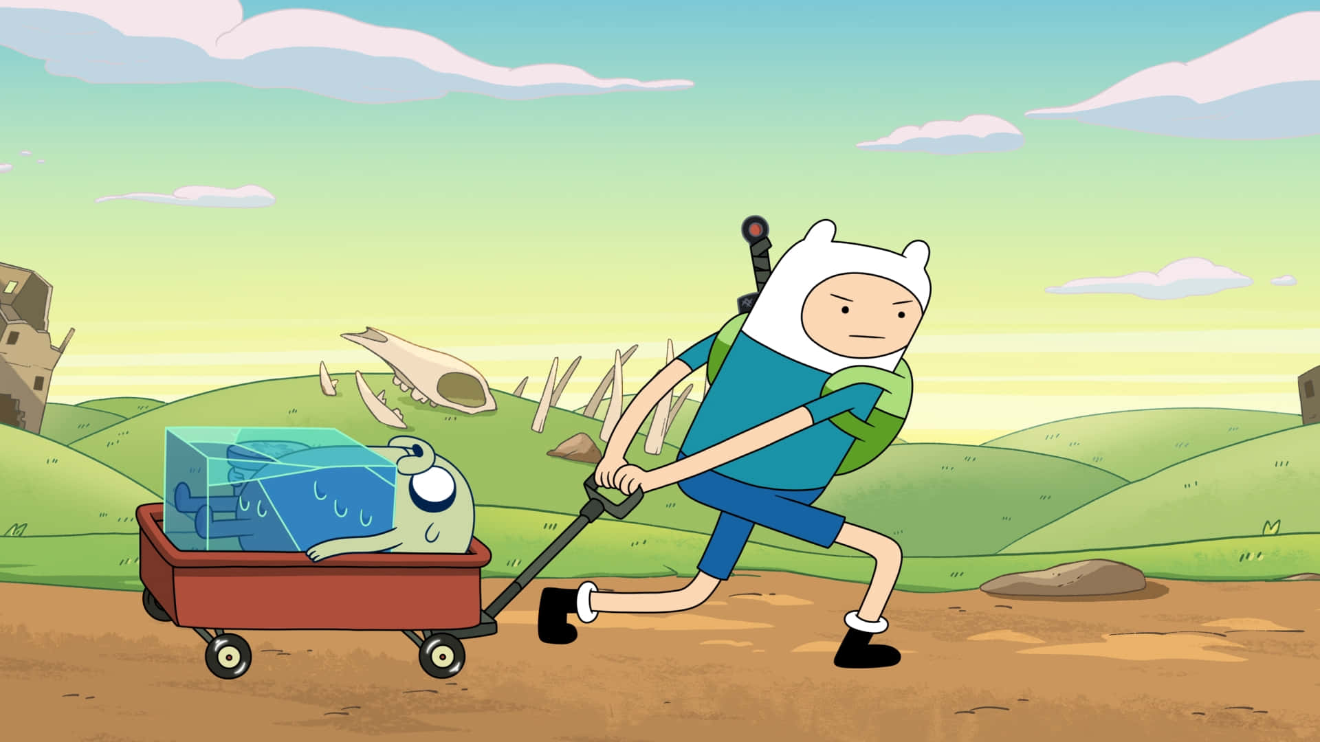 《Adventure Time》芬恩推車載傑克圖像 壁紙 — 冒險男孩拉著裝有藍色立方體生物的馬車，穿越起伏的綠色山丘，天空柔和。
