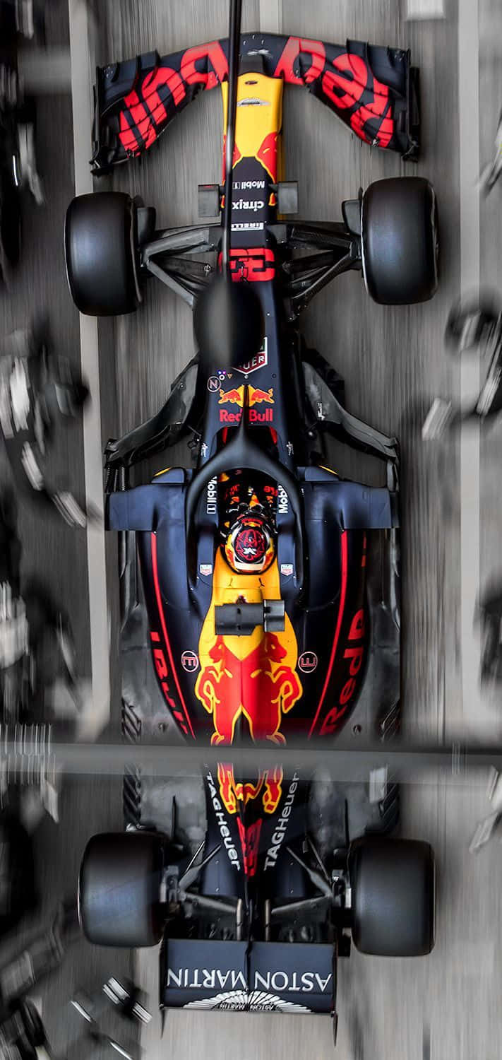 麥斯·韋斯塔本 桌布 壁紙 — Red Bull Racing 一級方程式賽車在賽道上高速行駛的空中視角，帶有動態模糊和反光表面。