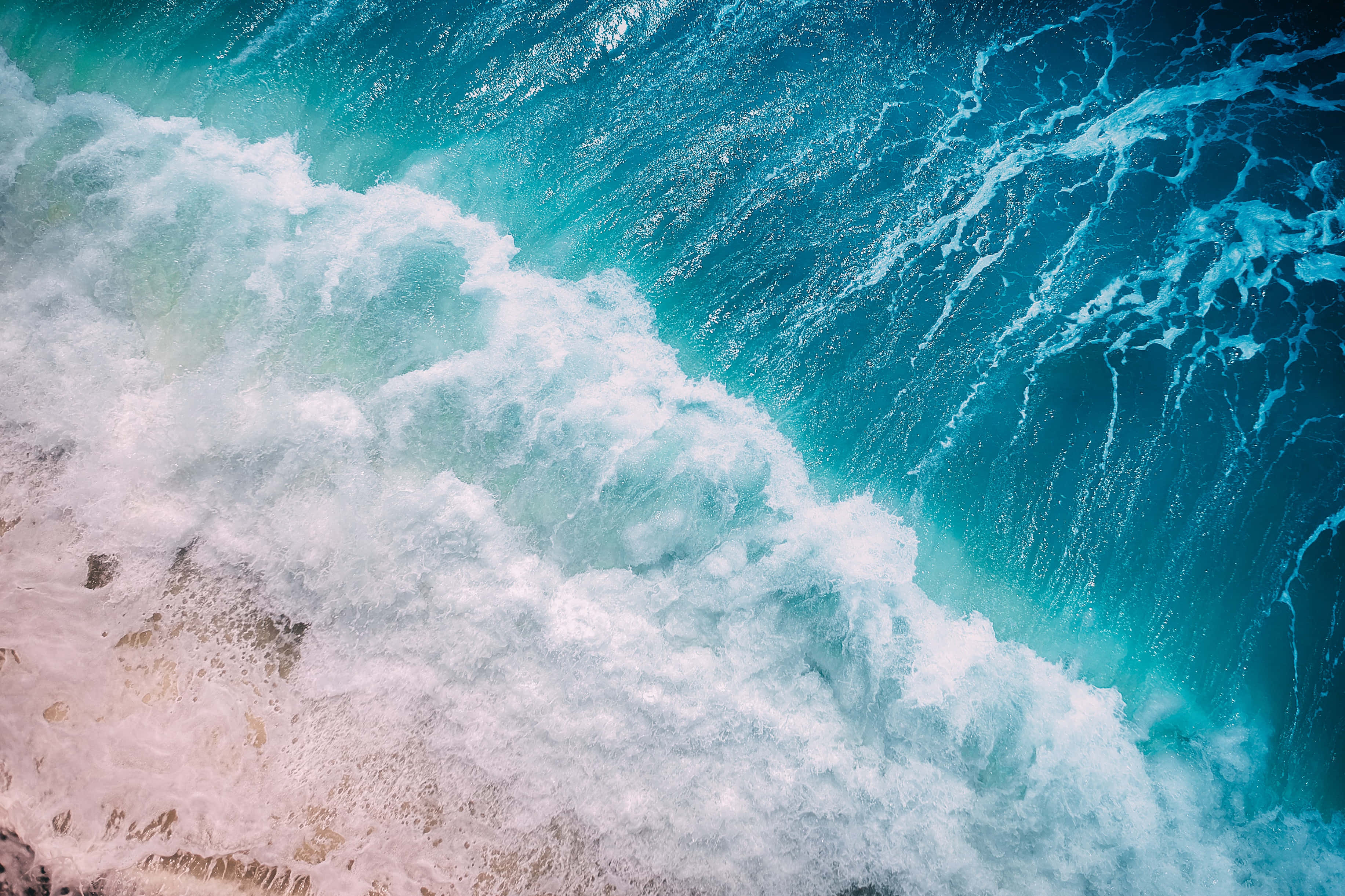 waves 桌布 壁紙 — 從高空俯瞰，綠松石色的海浪拍打著粉紅色的沙灘，泛起白色泡沫。