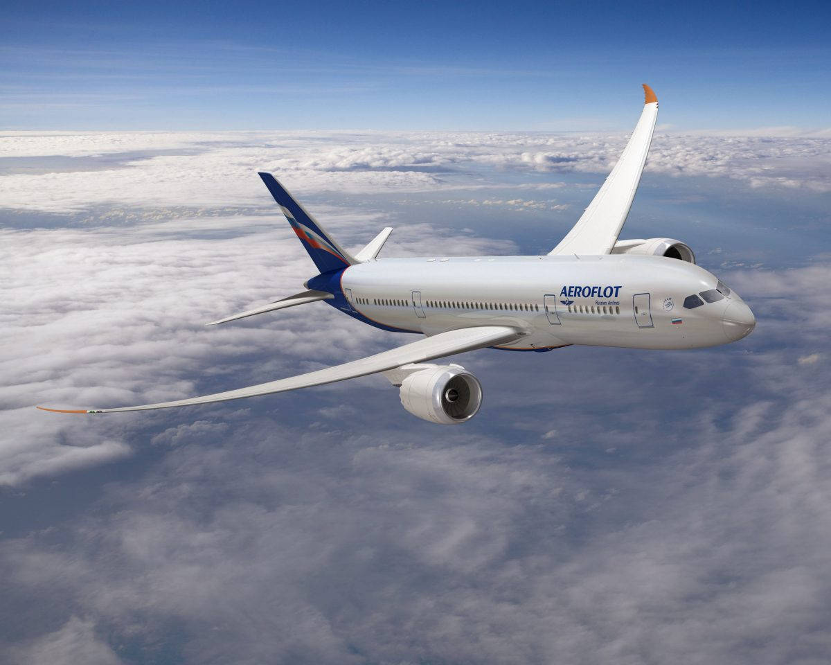 飛行中的 Aeroflot 航空公司飛機 壁紙 — 俄羅斯航空飛機在晴朗藍天下翱翔於蓬鬆白雲之上。