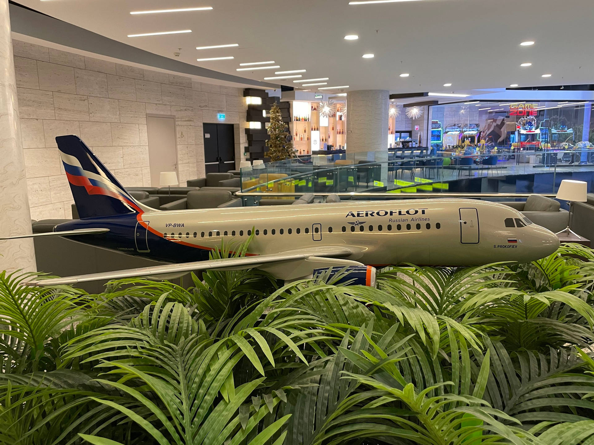 在現代機場休息室中被綠色蕨類植物包圍的Aeroflot飛機模型。