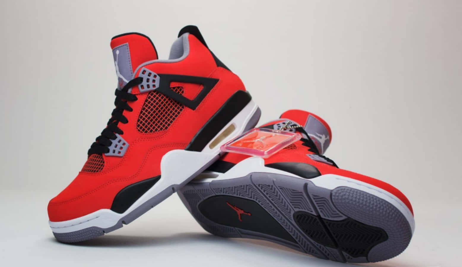 紅色和黑色的Jordan 4運動鞋，白色鞋底和可見的Air緩衝。