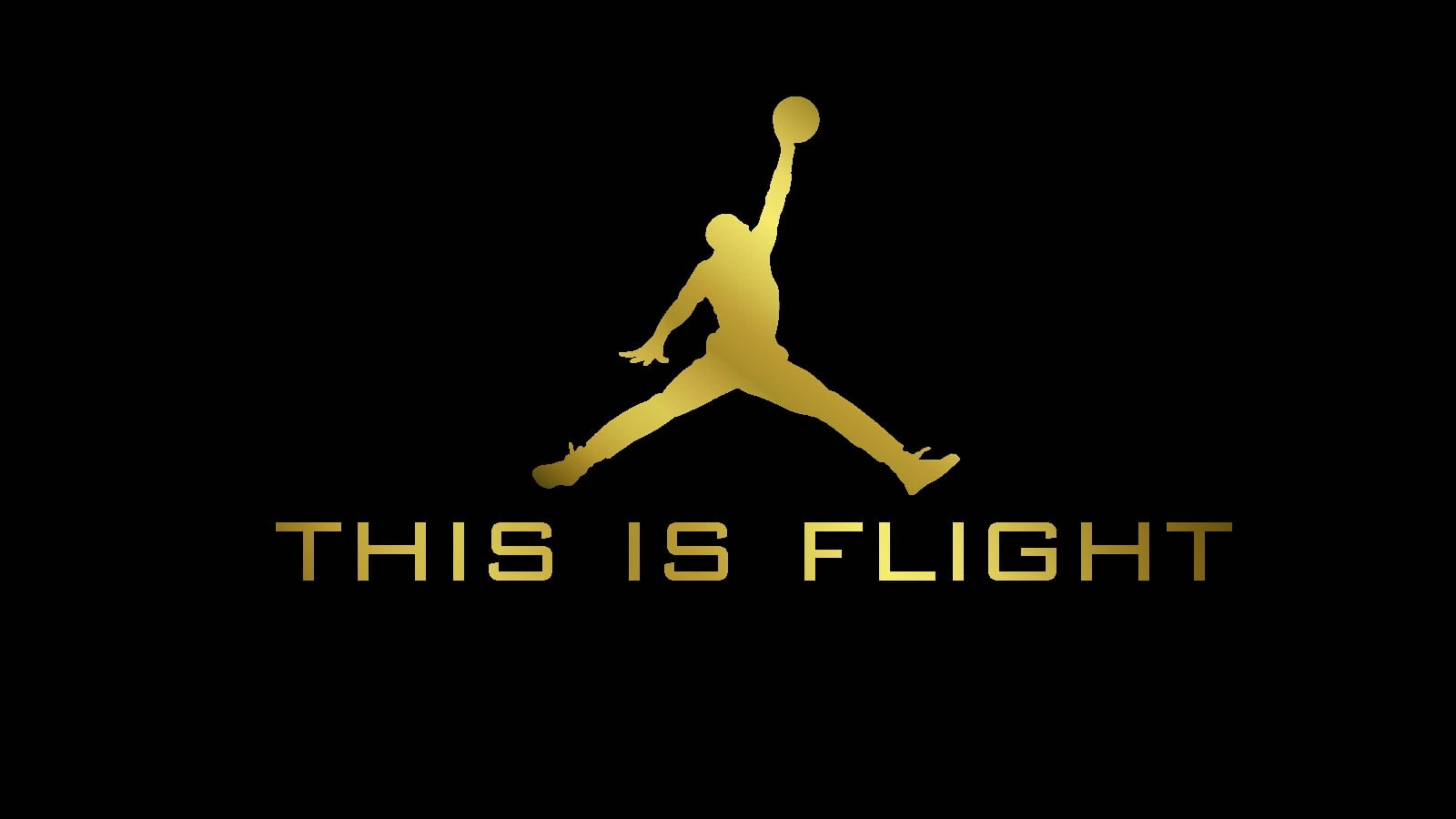 Air Jordan 飛行海報 壁紙 — 金色剪影，一個籃球運動員在半空中持球，黑色背景，下方有文字「THIS IS FLIGHT」。