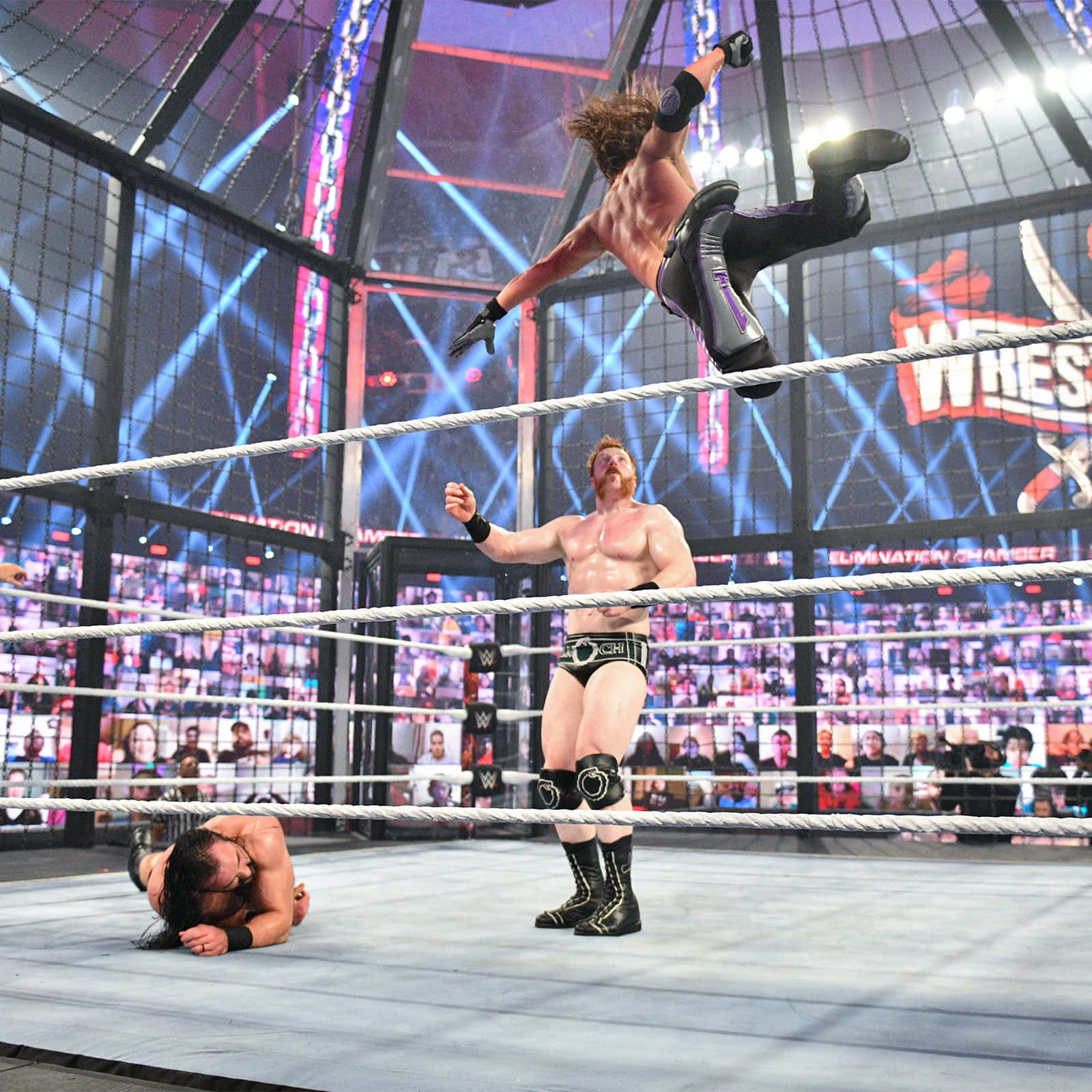 AJ Styles WWE 消除賽 壁紙 — 一名摔角手在鋼鐵籠比賽中從頂繩躍下，對手準備就緒，而倒下的對手則在下方敗陣。