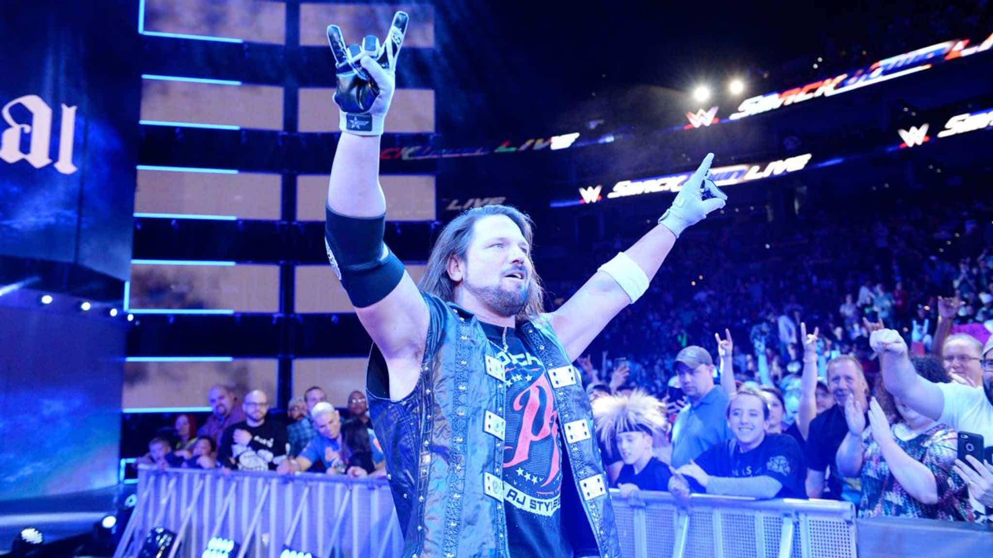 AJ Styles於WrestleMania 33賽事勝利 壁紙 — 摔角手蘭迪·奧頓在燈光明亮的場館中高舉雙臂慶祝勝利，粉絲們歡呼雀躍。