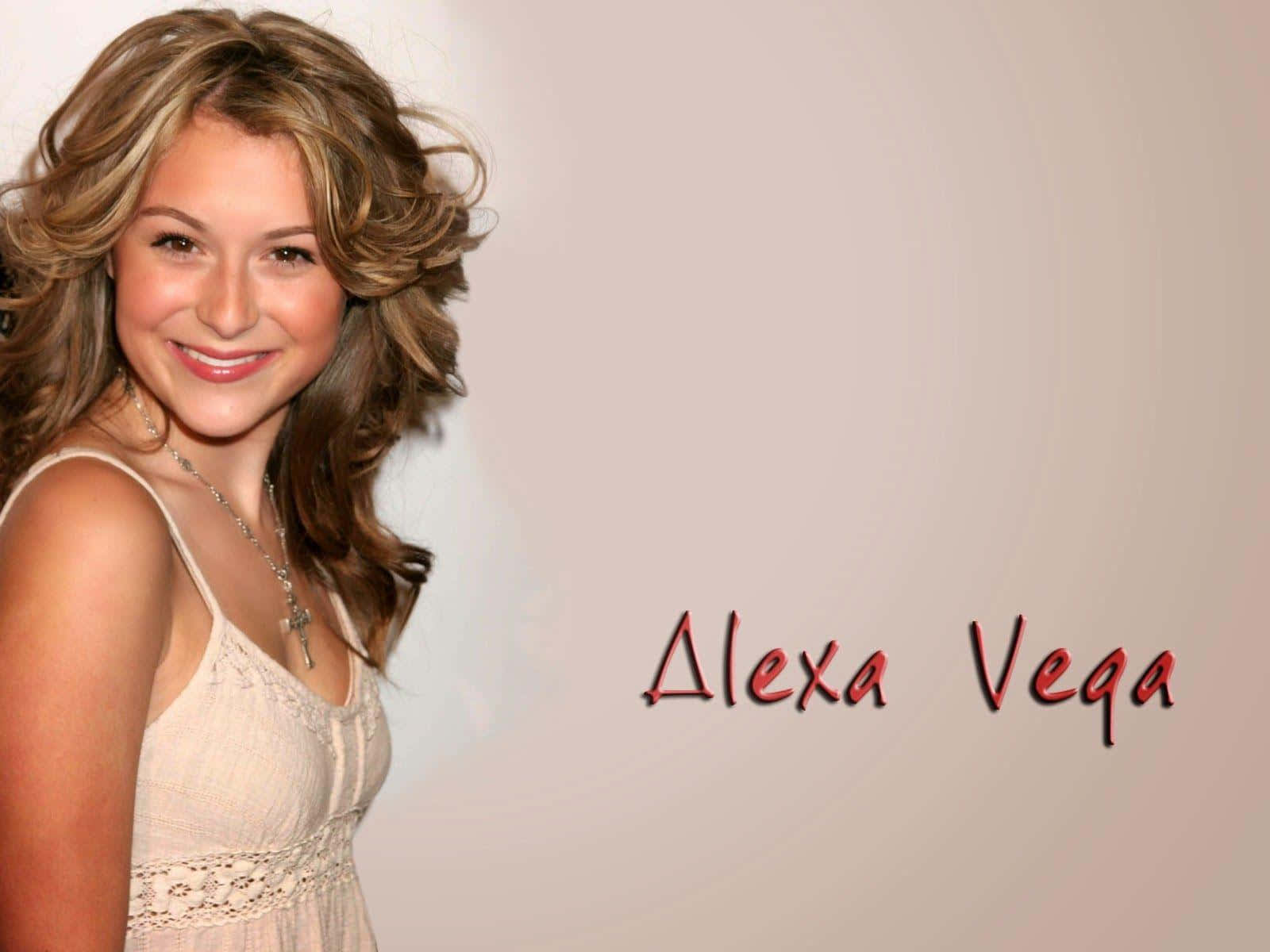 Alexa Penavega 桌布 壁紙 — Alexa Vega 喺柔和米色背景前，穿著奶油色蕾絲上衣，溫暖微笑，佢個名用紅色寫出嚟。