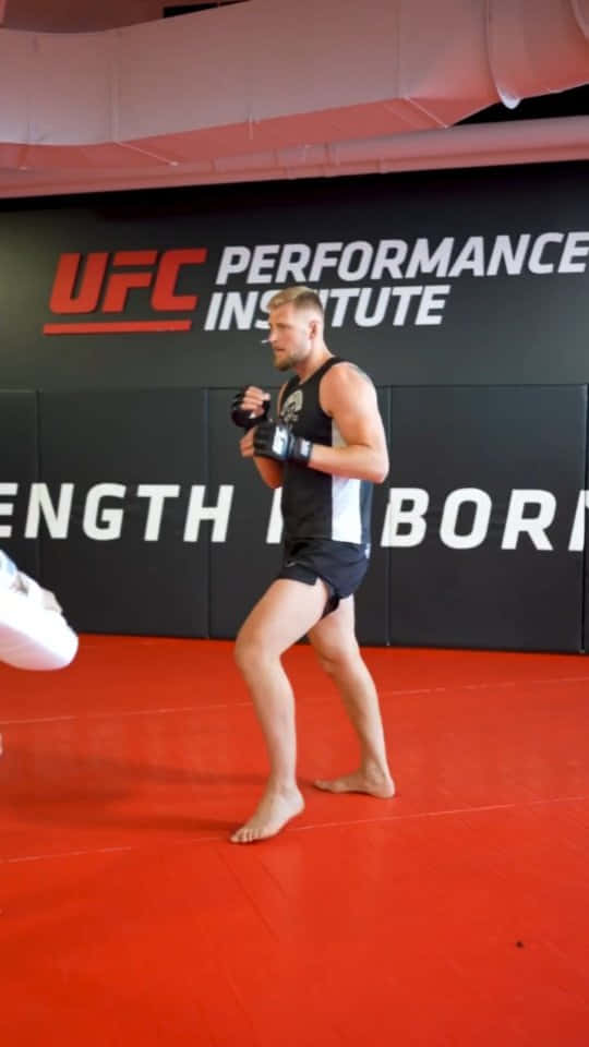 男性拳手在UFC Performance Institute健身室的紅色地墊上訓練。