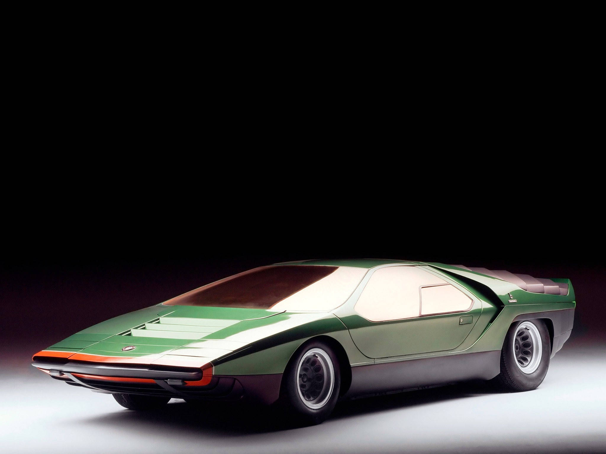 Alfa Romeo iPhone 綠色 壁紙 — 一輛時尚的綠色和白色未來主義跑車，帶有橙色點綴，在黑色背景的攝影棚燈光下閃耀。