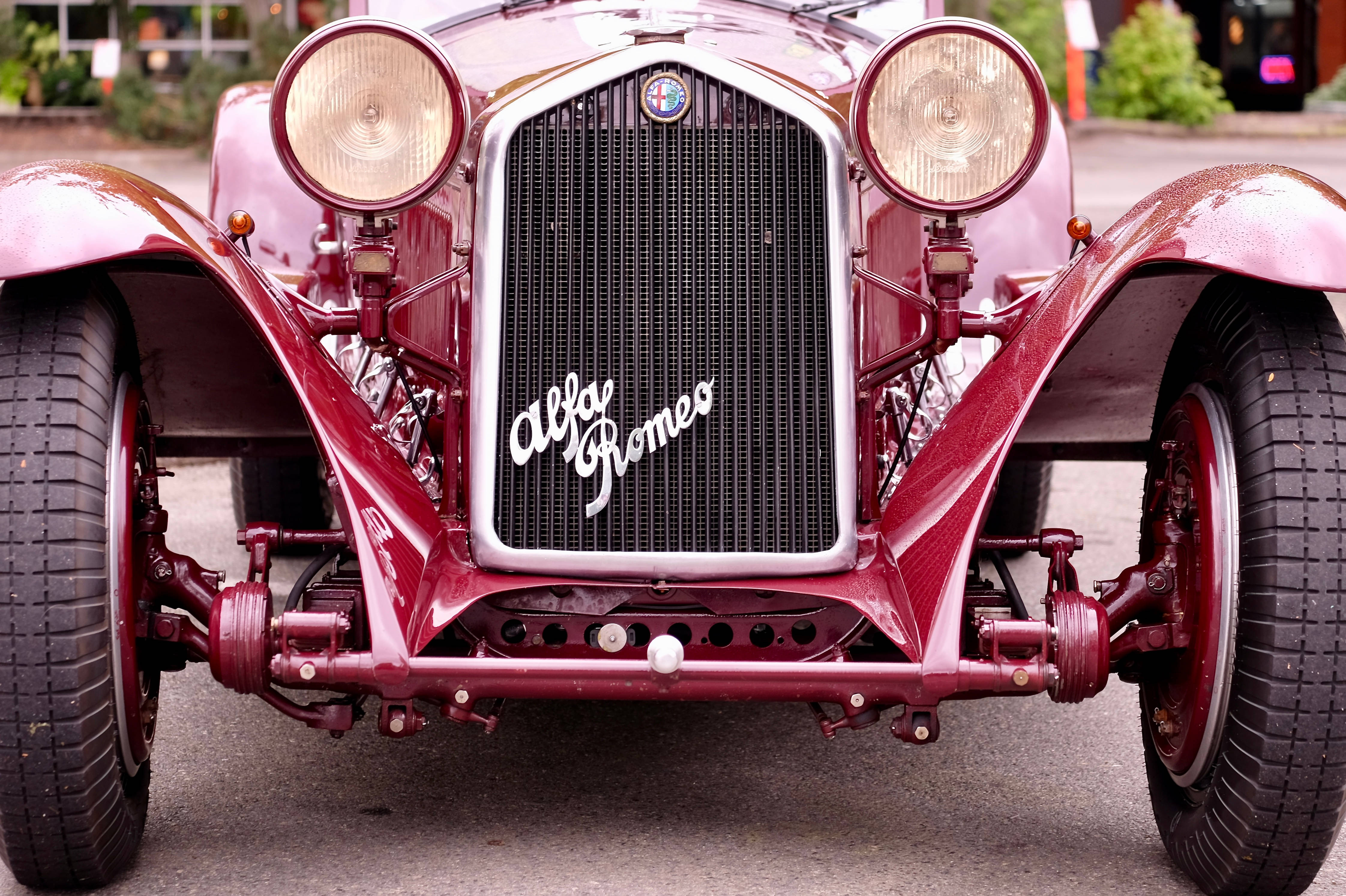 Alfa Romeo Torpedo 20-30 HP 壁紙 — 一輛復古酒紅色愛快羅密歐汽車的特寫，展示其標誌性格柵和圓形頭燈。