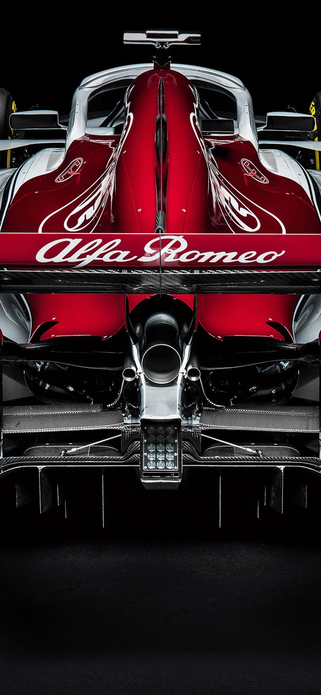 Alfa Romeo賽車iPhone XS F1 2018背景 壁紙 — 黑色背景前，紅色和銀色愛快羅密歐一級方程式賽車的戲劇性後視圖。